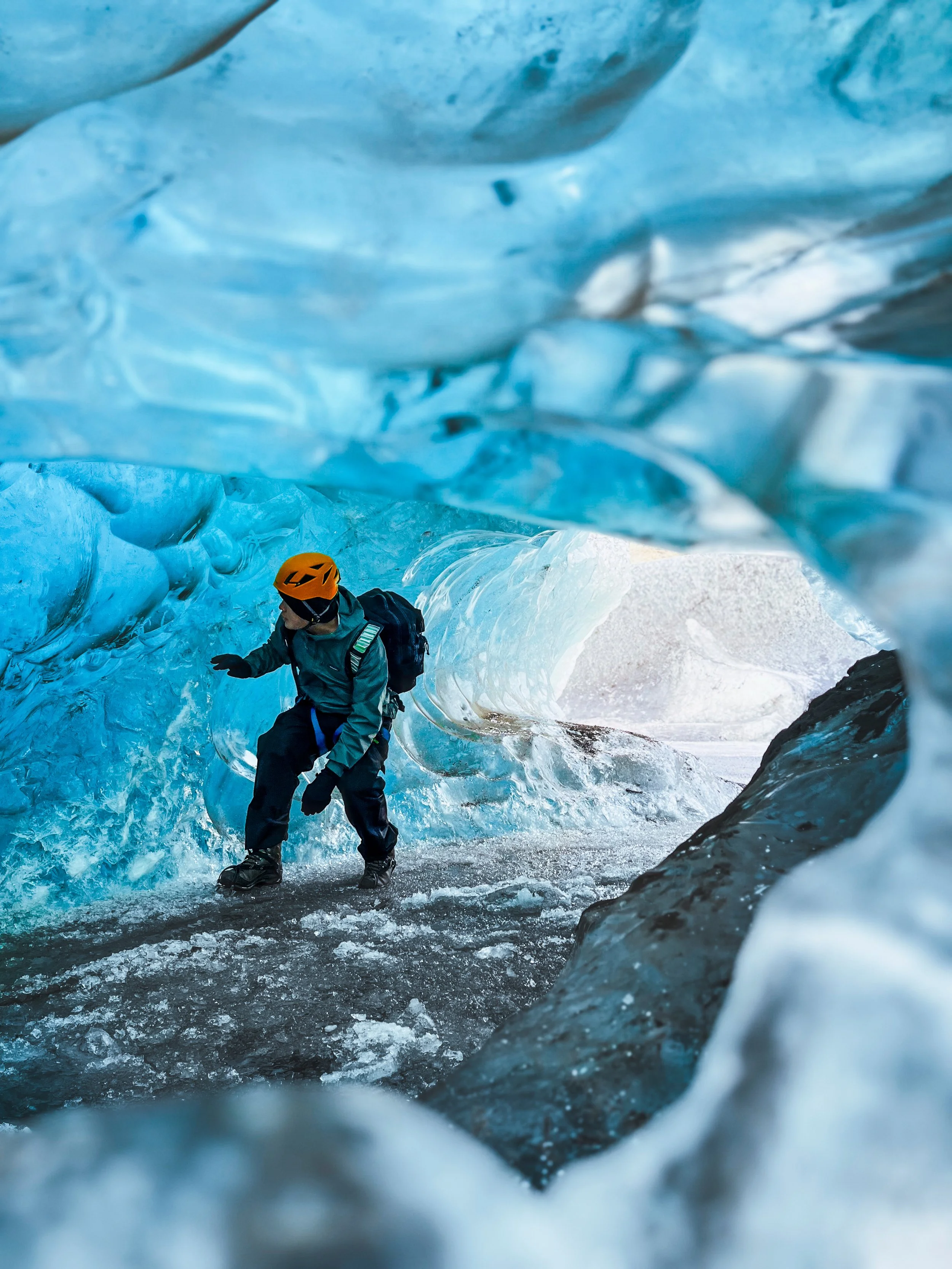 Tourist exploring the ice cave on a small group tour in Iceland