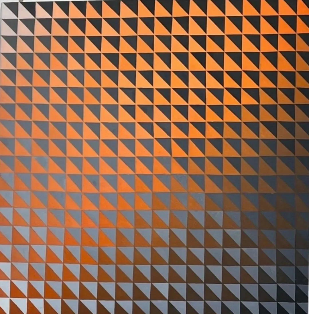 Close-up of a geometric pattern featuring a grid of small orange and black triangles.
