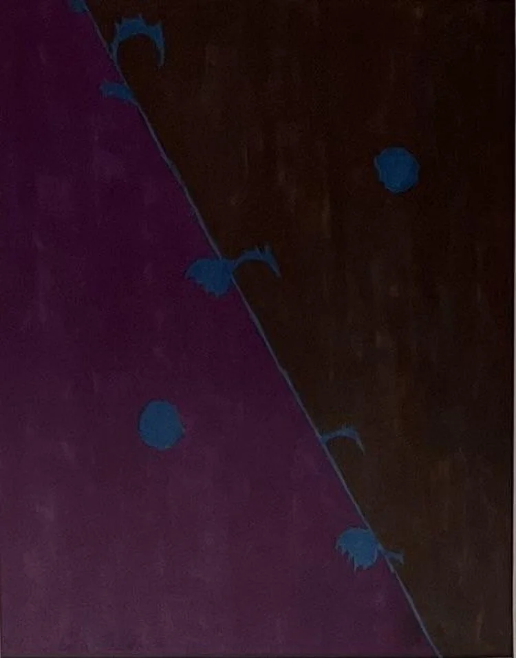 Close-up of a dark wooden surface with a strip of purple fabric and small blue floral embellishments.