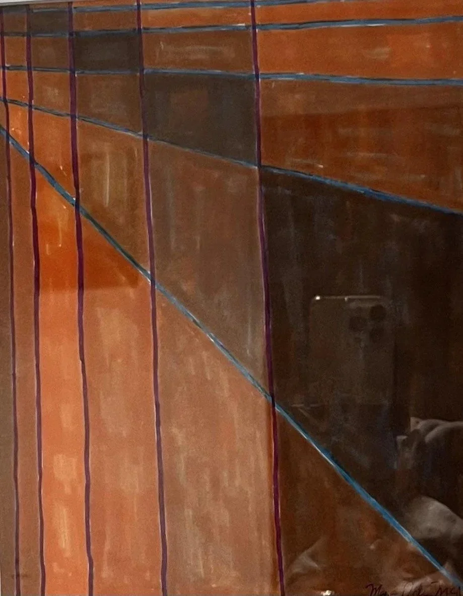 Close-up of a glass window with colorful vertical and diagonal decorative lines reflecting a person taking a photo with a smartphone.