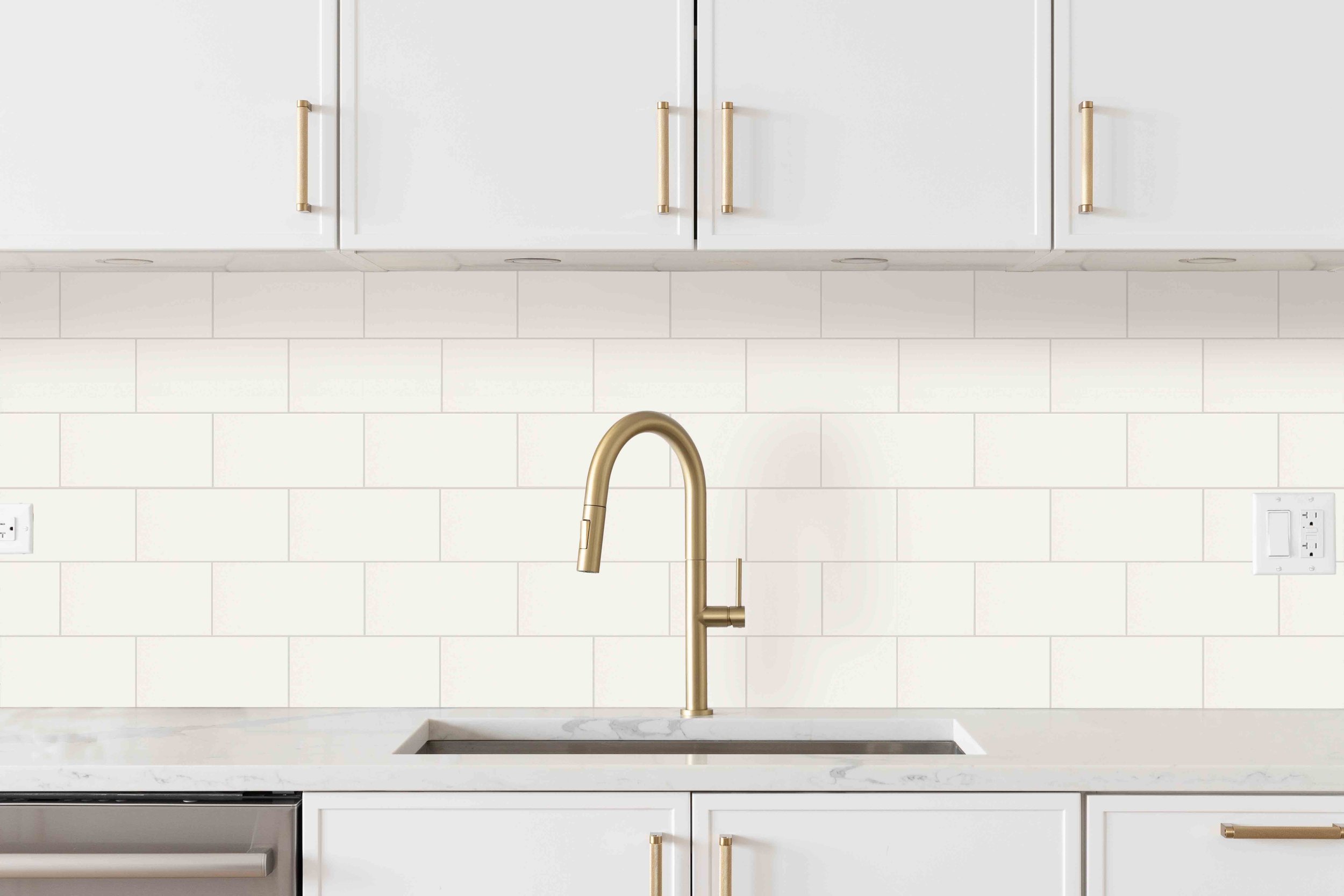 Modern kitchen with white cabinets, a gold faucet, and DuraWall white tile backsplashs installed on walls.