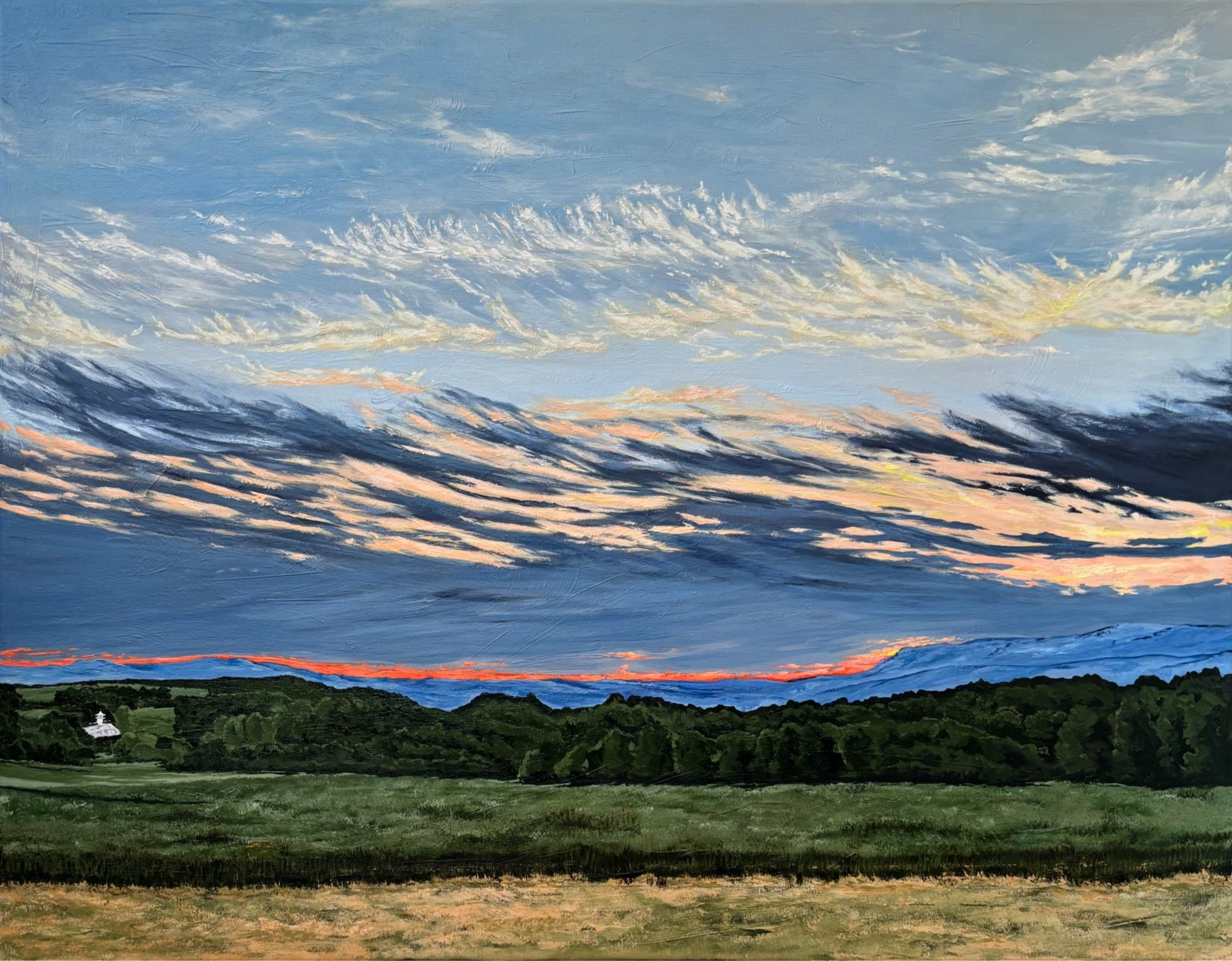 Sunset over a rural mountainscape and farm land below. 