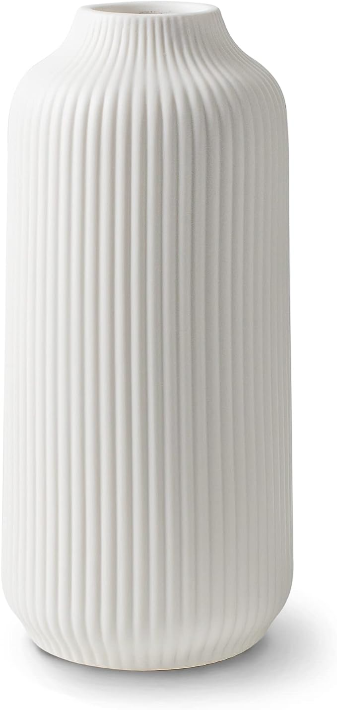 White ceramic vase with vertical ribbed texture and rounded shape.