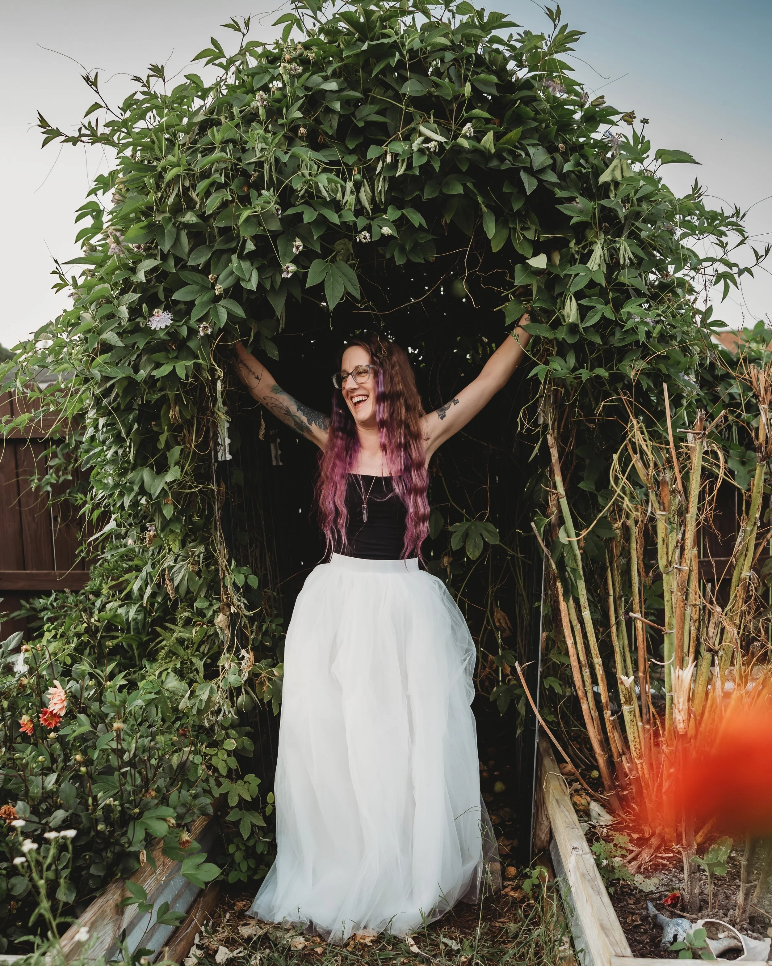 Kat Harrison, artist and intuitive coach, posing in a relaxed, creative environment.