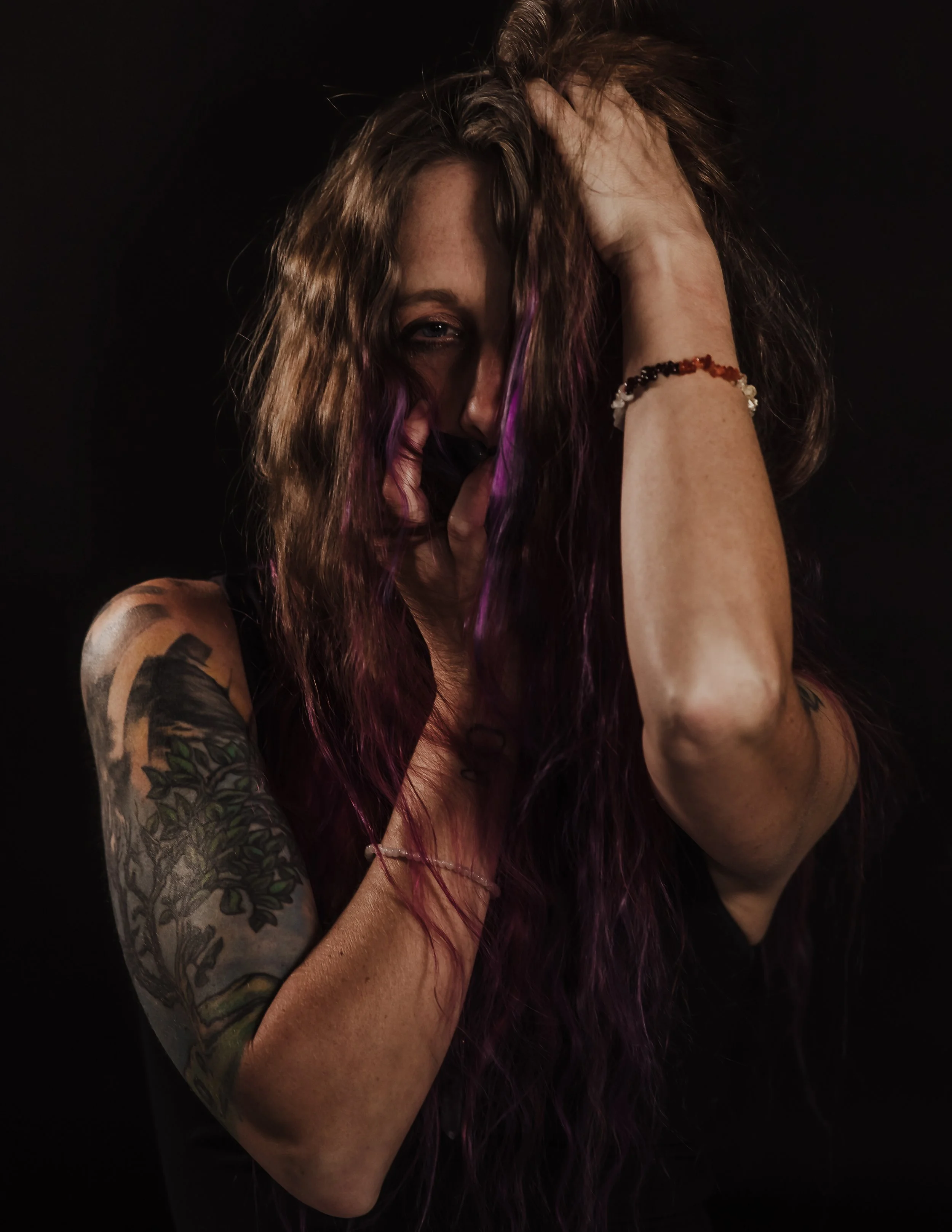 Artistic photo of Kat Harrison with hair covering face, representing vulnerability, introspection, and self-expression.