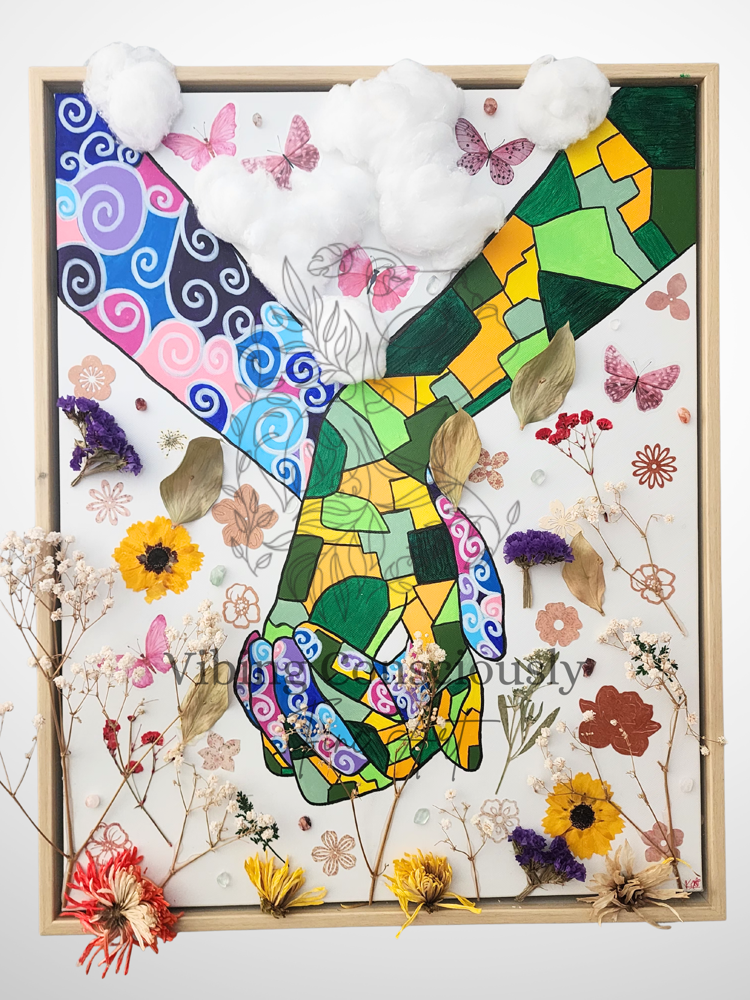 Mixed media artwork featuring two hands holding each other and a colorful butterfly with stained glass style wings, surrounded by dried flowers, pressed leaves, and butterflies.