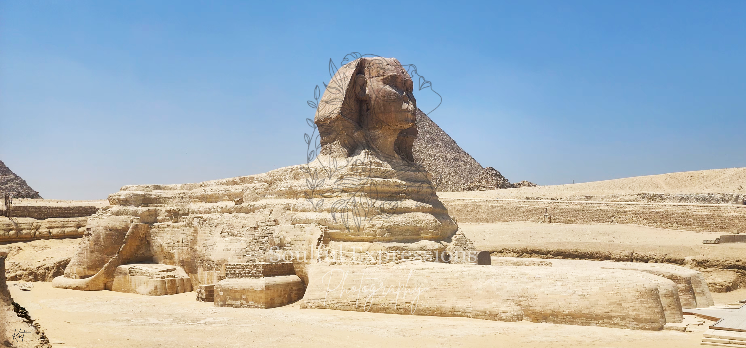 The Great Sphinx of Giza in Egypt with the pyramids in the background under a clear blue sky.