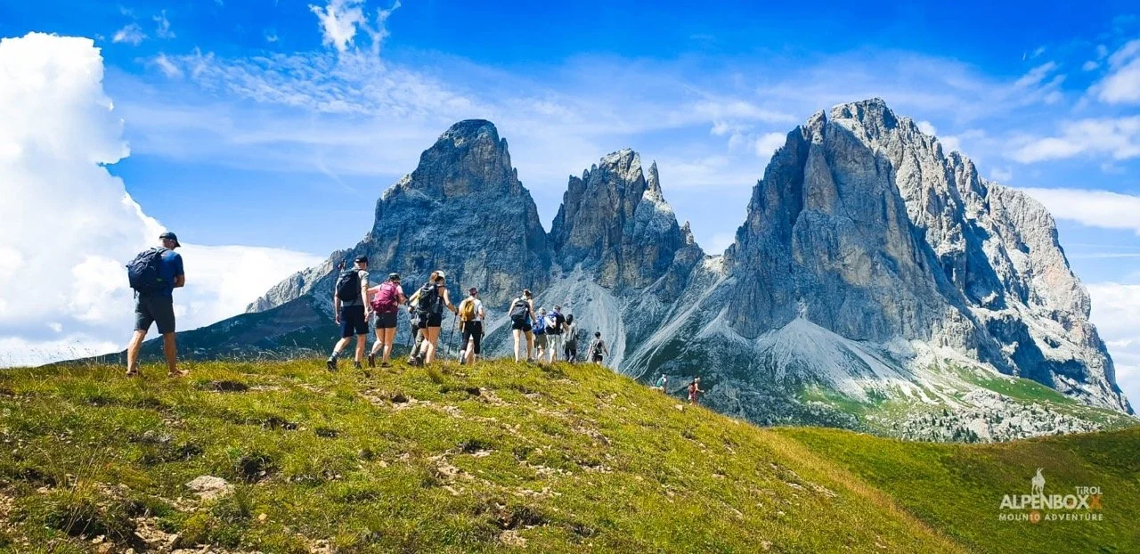 Hiker on a rocky mountain ridge with clouds in the background