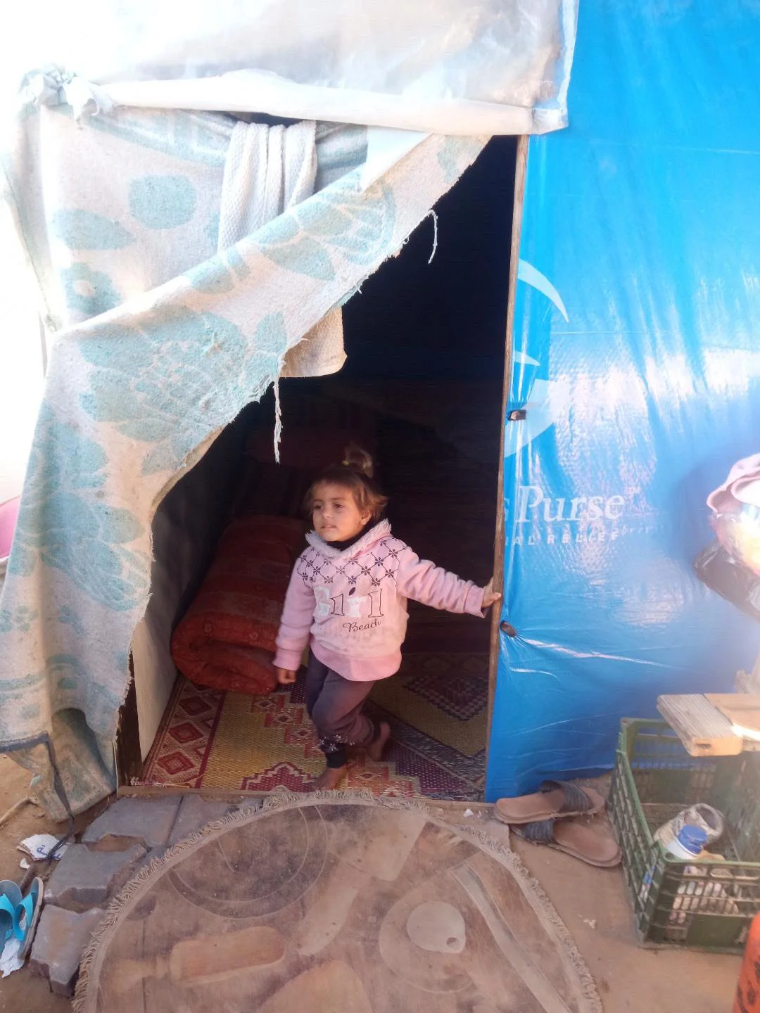 Fadi Qadih daughter in front of tent home 12-09-25.jpeg