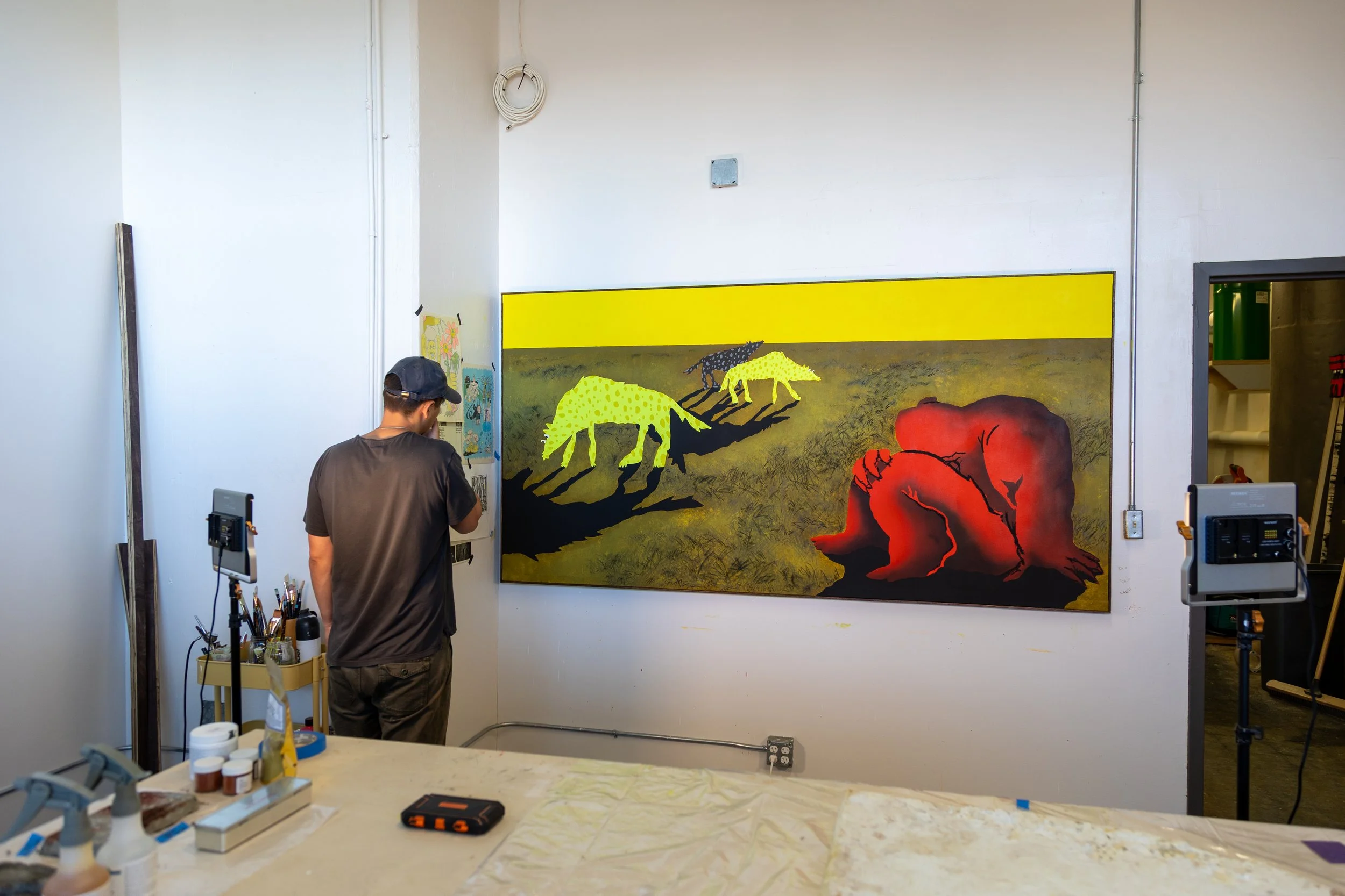 Lomakin with his painting 'Can I pet that dog?' in his studio.
