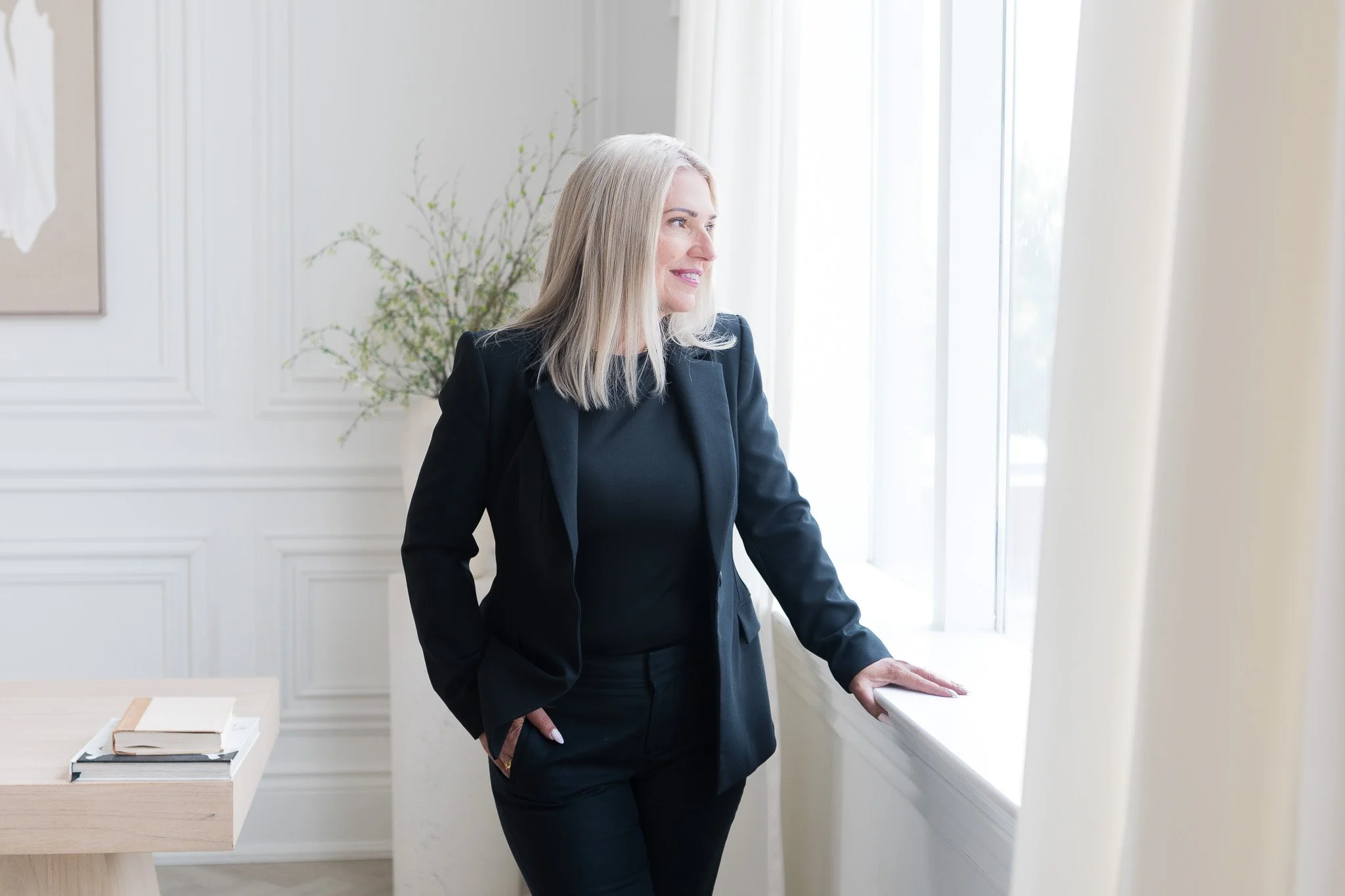 woman-black-suit-staring-out-window