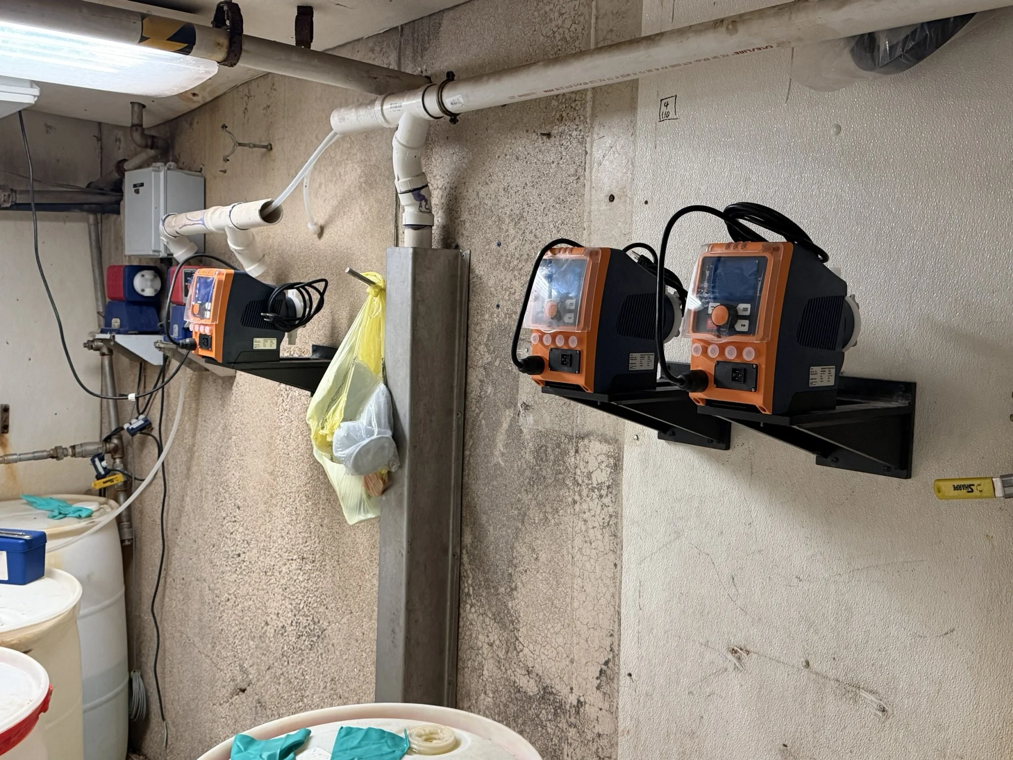 Chemical feed pumps and tubing installed for process control at a poultry processing facility.