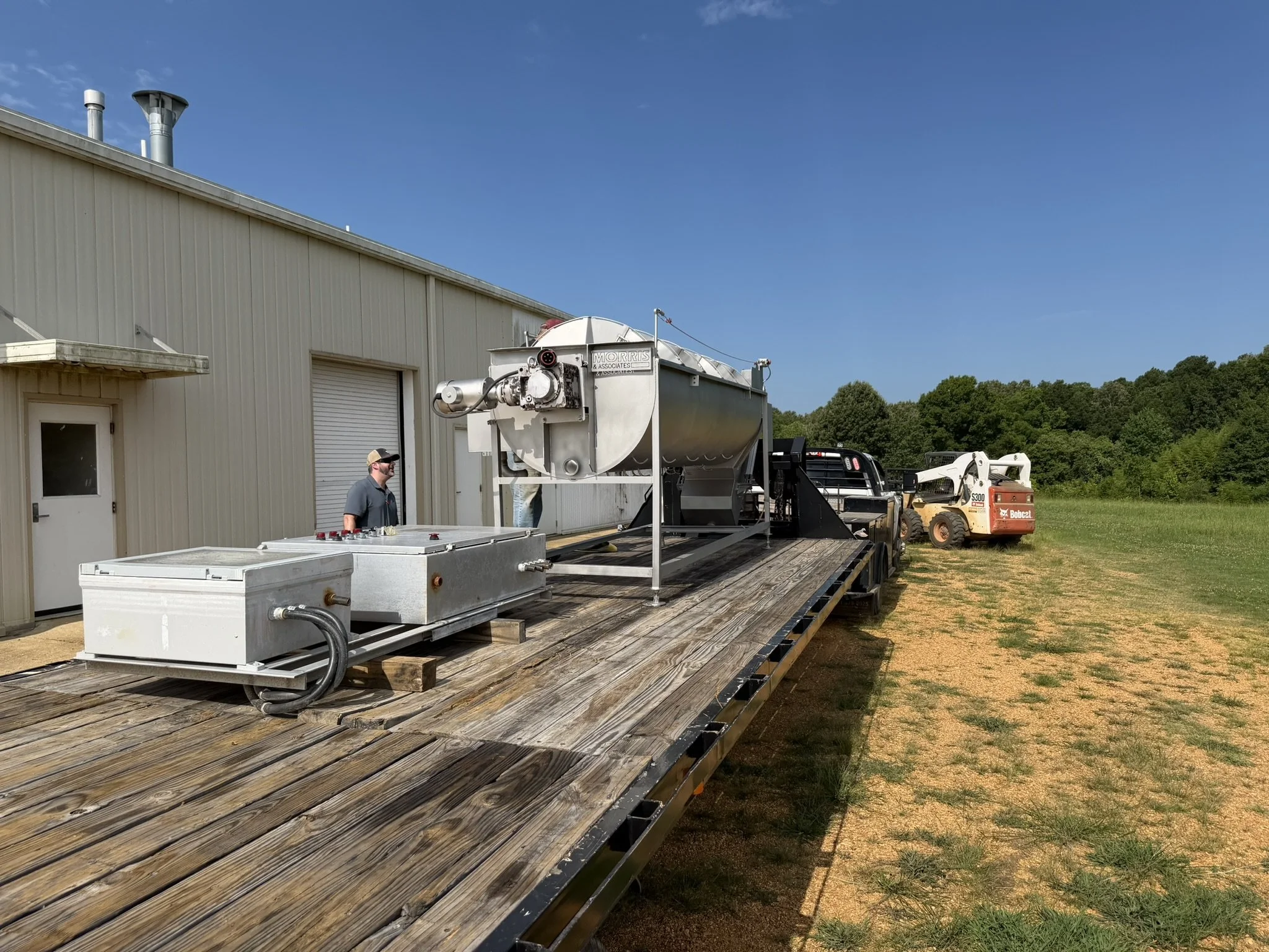 Field service equipment and processing machinery staged for installation at a poultry facility.