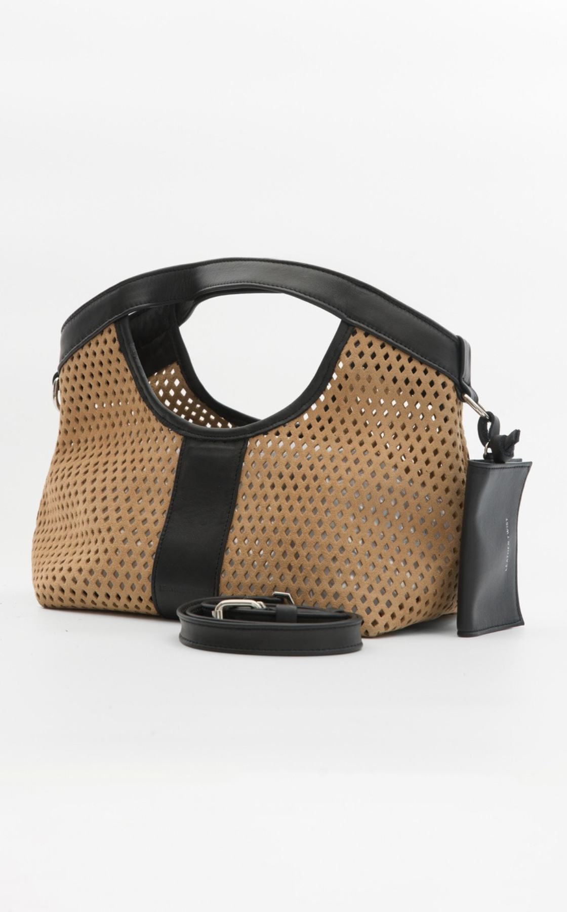Tan and black perforated handbag with detachable strap and attached black leather tag.