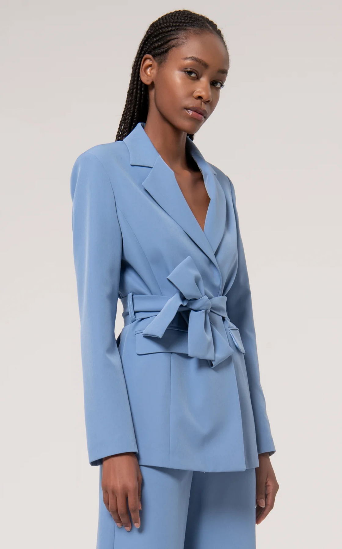 Woman wearing light blue blazer with belt