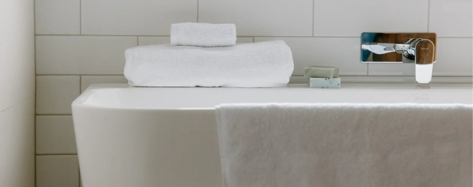 Stacked Tasman white towels on a bathroom. Commercial hospitality towels and linen for hotels, motels and accommodation providers 