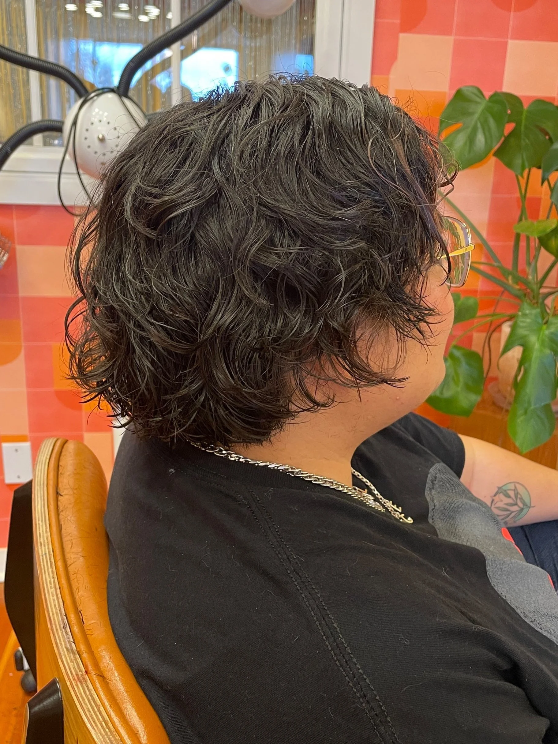 Short wavy curly queer non binary haircut
