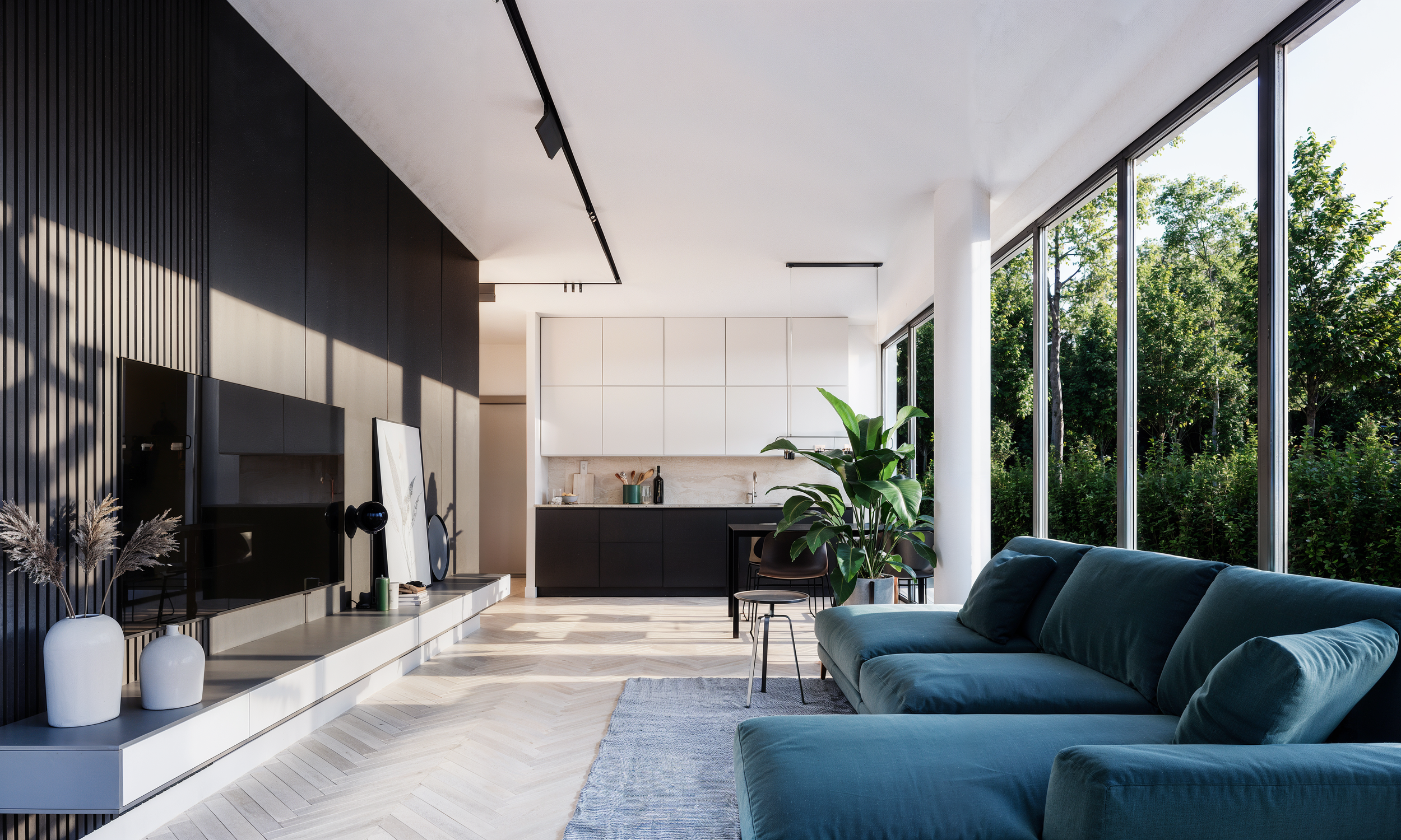 Modern living room with large windows, blue sofa, potted plant, and minimalist kitchen in the background.