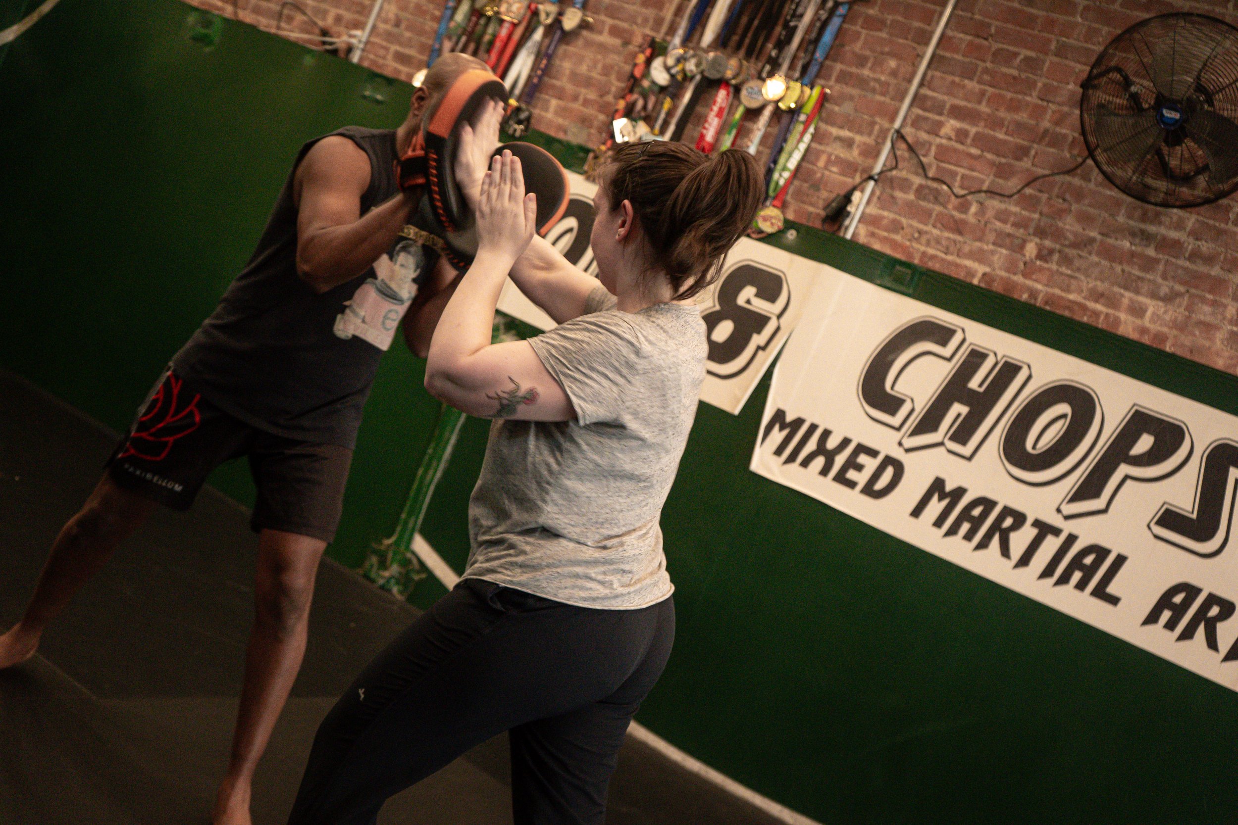 Two students practicing self-defense moves at the Chop and Chops MMA gym in Brooklyn.