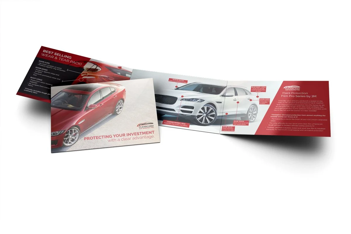 Open tri-fold brochure with a red sports sedan on the front cover and interior details of a white car, including labels for body parts like doors, fenders, and bumpers, with red and white color scheme and promotional text.