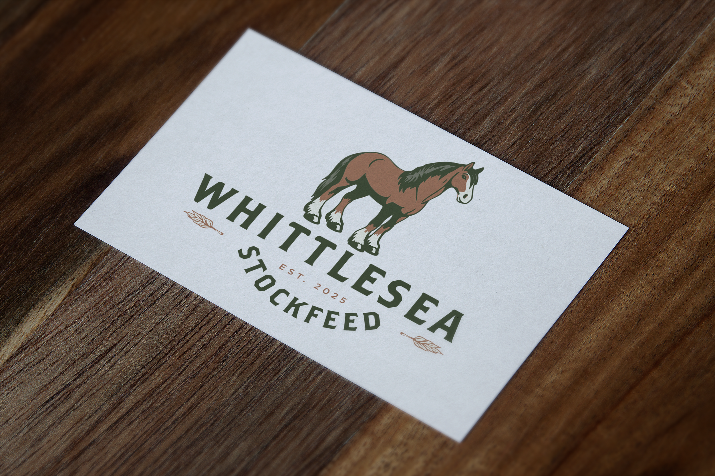 Business card for Whittlesea Stockfeed featuring a horse and wheat graphic on a wooden surface.