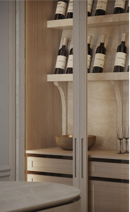 Wine bottles on white shelves inside a wooden cabinet, with a wooden bowl and two champagne flutes on a shelf below.