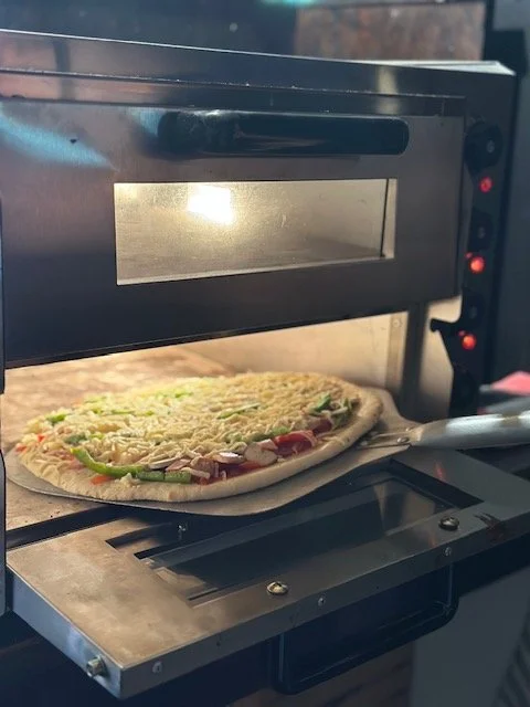A pizza being baked in a commercial pizza oven