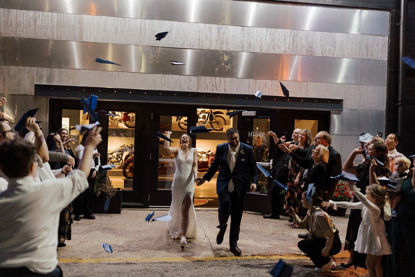 exterior night shot of bride and groom grand exit from their wedding at smith and company event space at the moto museum event venue st. louis