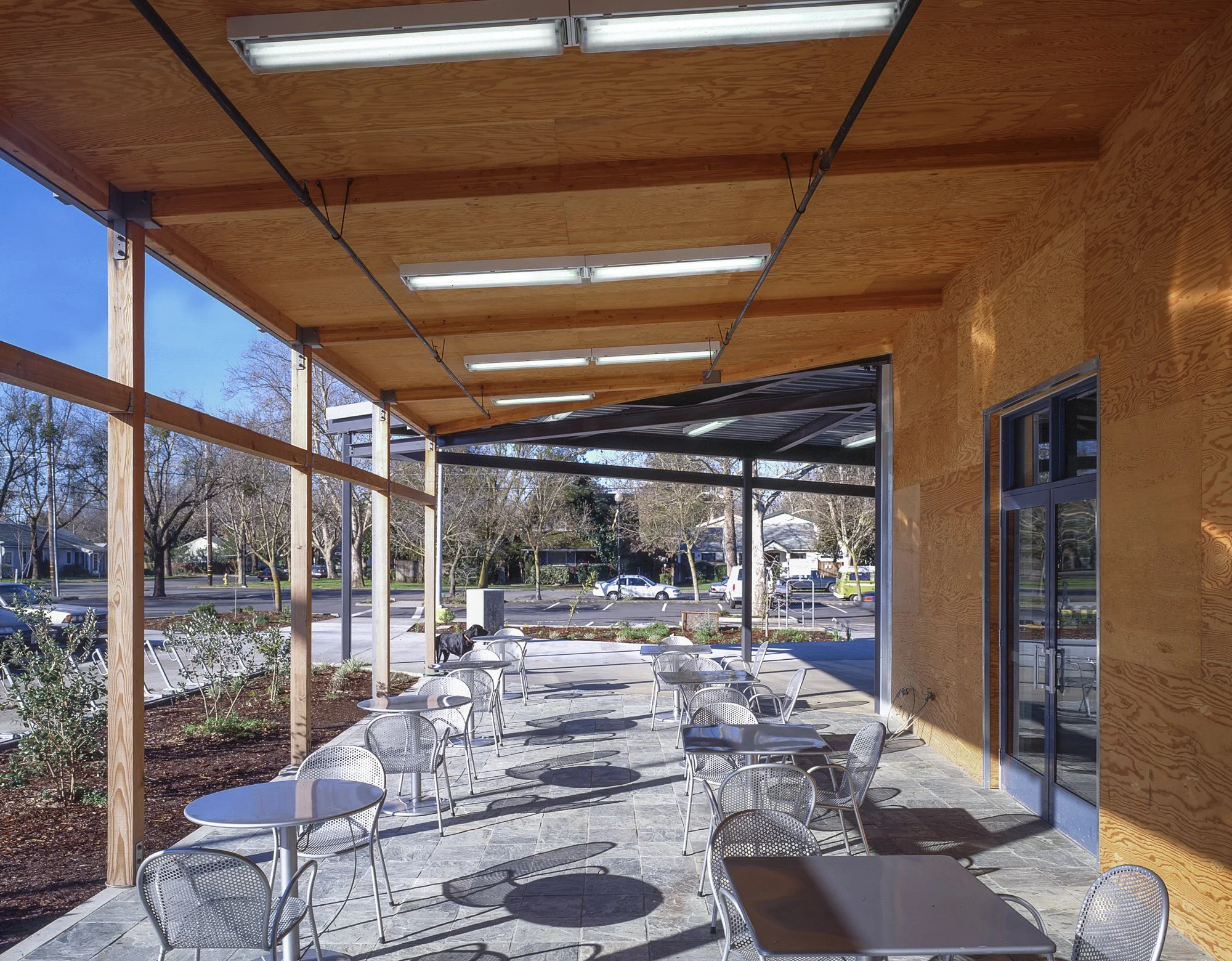 The entry extends to a metal and wood dining patio for catching a bite and hanging out with friends.