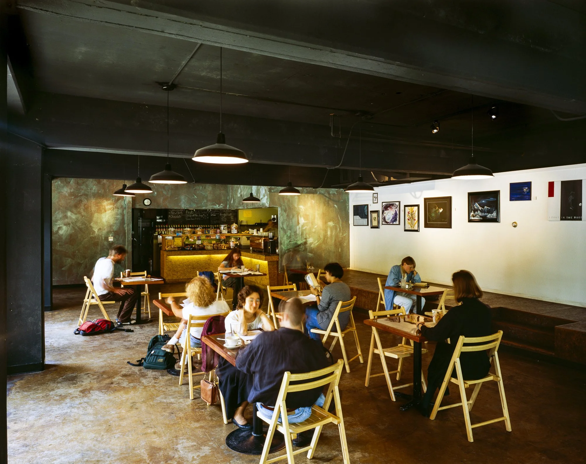 Inside the café, an 18-foot-long stage along the back wall provides performance options and extra seating when needed. A rotating art display runs above the stage: all in the service of liquid culture.