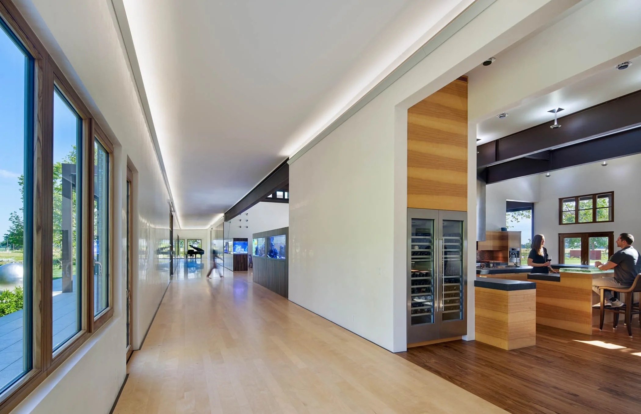 The initial transverse, a 200-foot-long hallway, connects to the house’s two private wings.