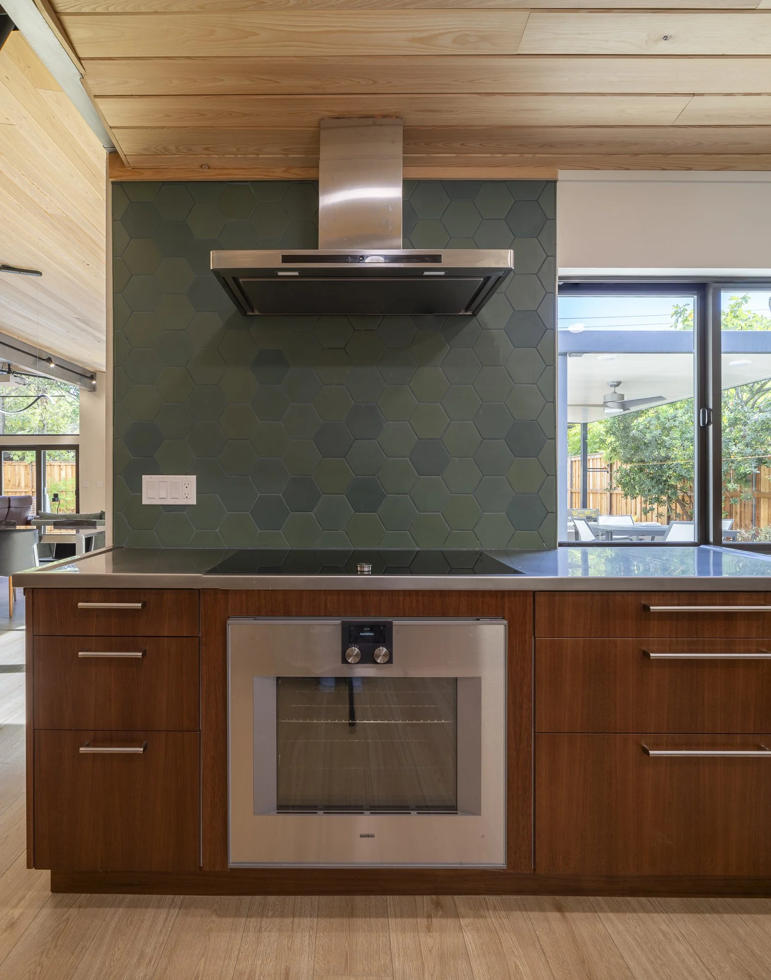 We pushed out the kitchen to accommodate a pass-through window connecting to a new patio dining area, enhancing indoor-outdoor flow for entertaining.