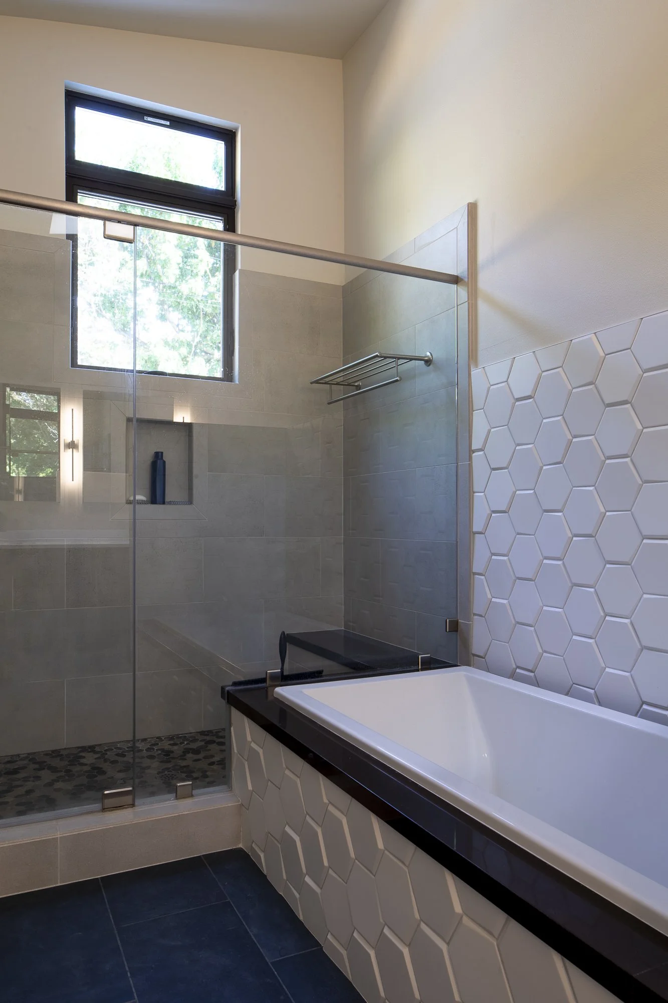 The white hexagonal tiles create a cohesive design story, tying the master area back to the great room by referencing the green hexagonal kitchen tiles.