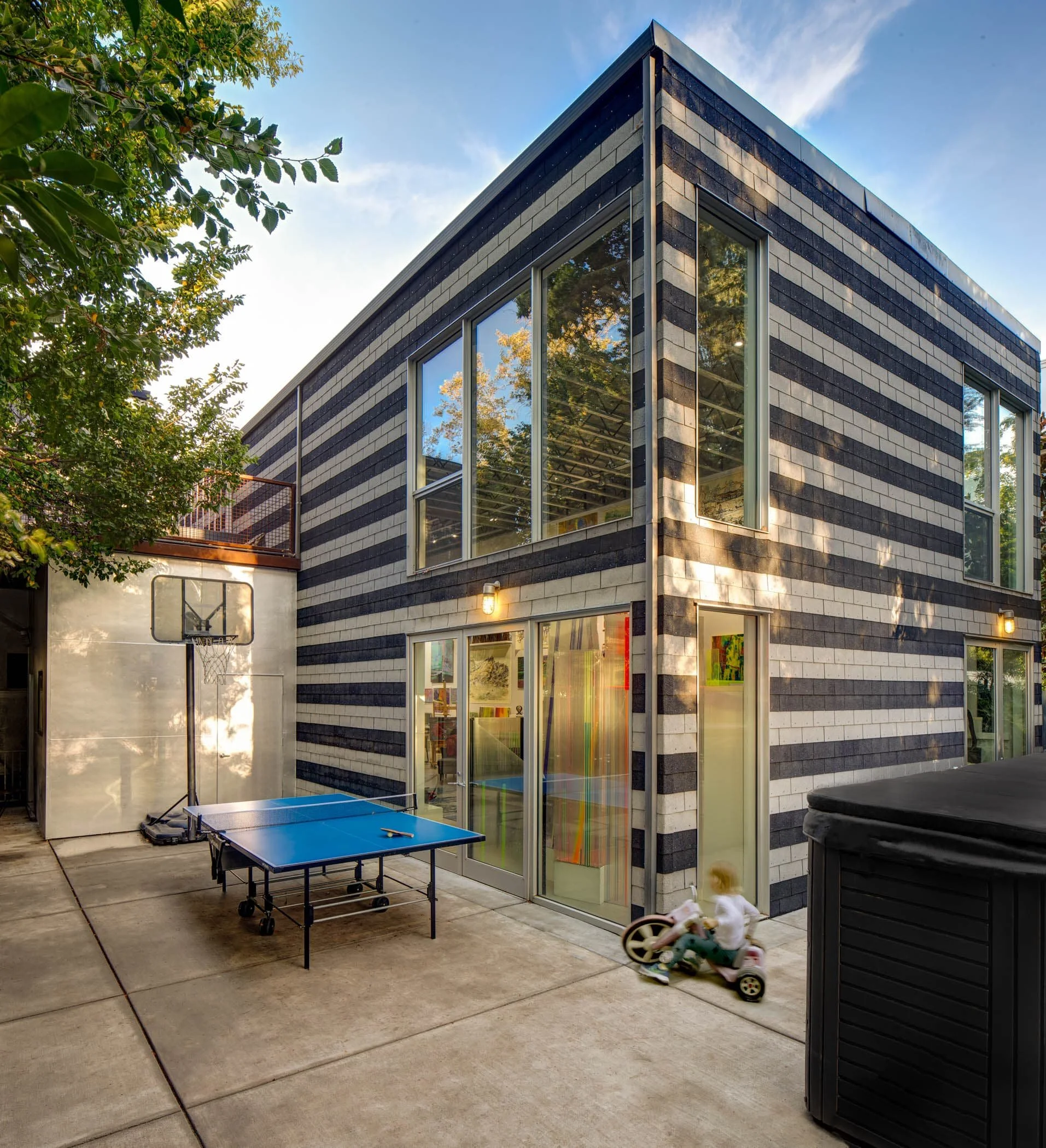 The exterior horizontal black and white stripes, built by hand from affordable roofing tiles and concrete, draw inspiration from medieval Genoan stonework and recall Central Valley crop rows.