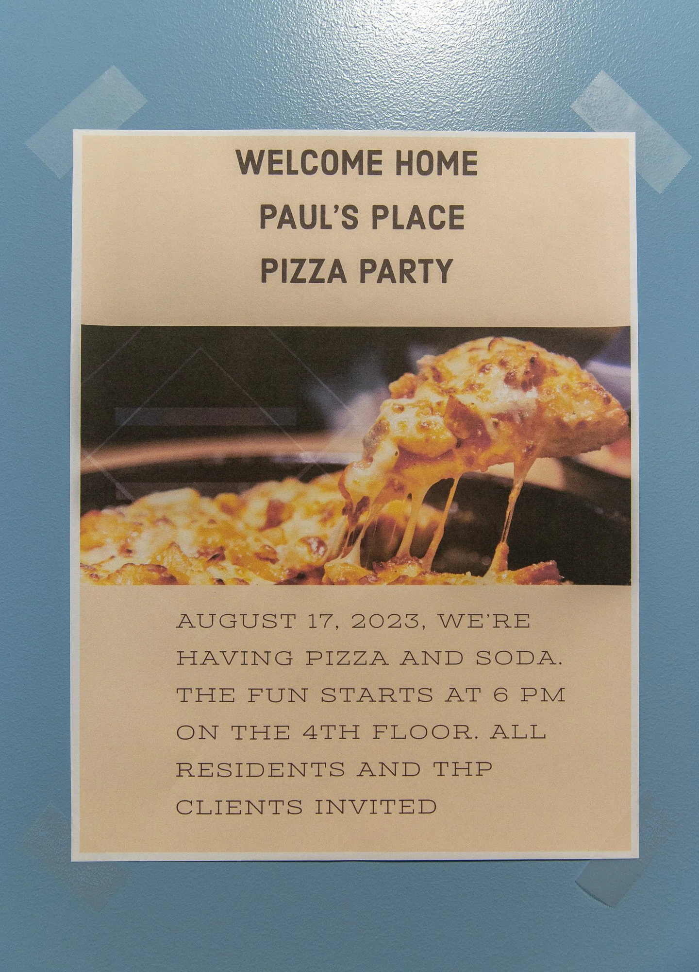 The elevator area showcases gathering opportunities like a pizza party for new residents.