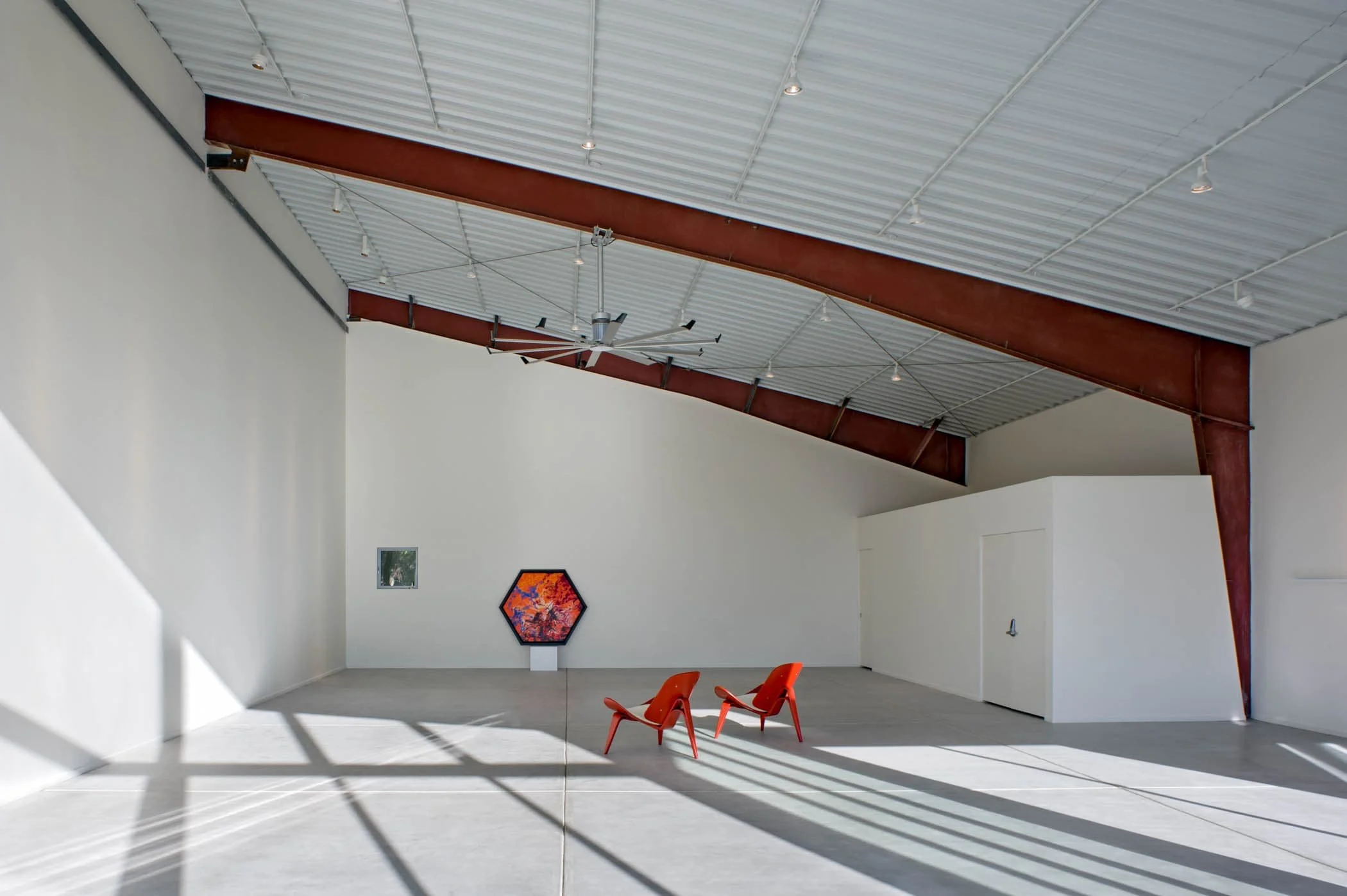 The interior architecture exposes and accentuates the angled steel barn structure, and the size of the barn creates large walls for hanging art.
