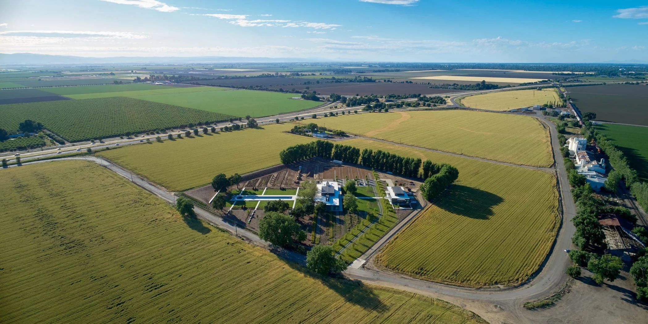 The homestead sits on a rotated axis, oriented to maximize southwest breezes and sunset views. The long, rectangular main house and garage-guest suites intersect the spine at the middle and one end. The Olympic-size pool extends the spine in the othe