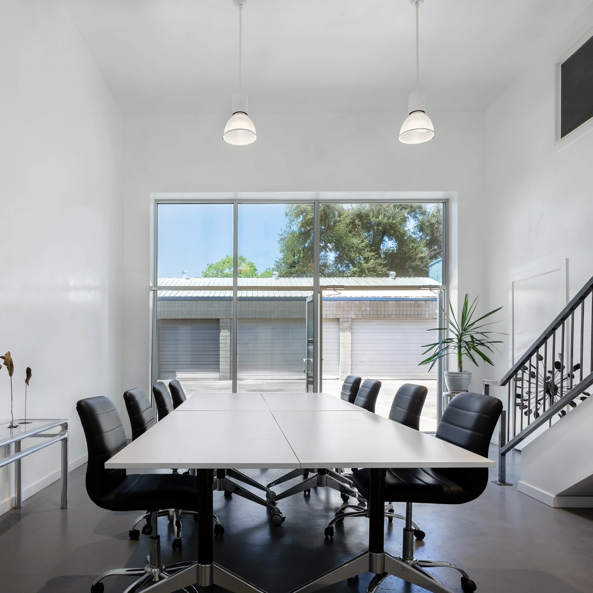 The main conference room features another picture window with an integrated glass door, connecting to the sky and sun outside.