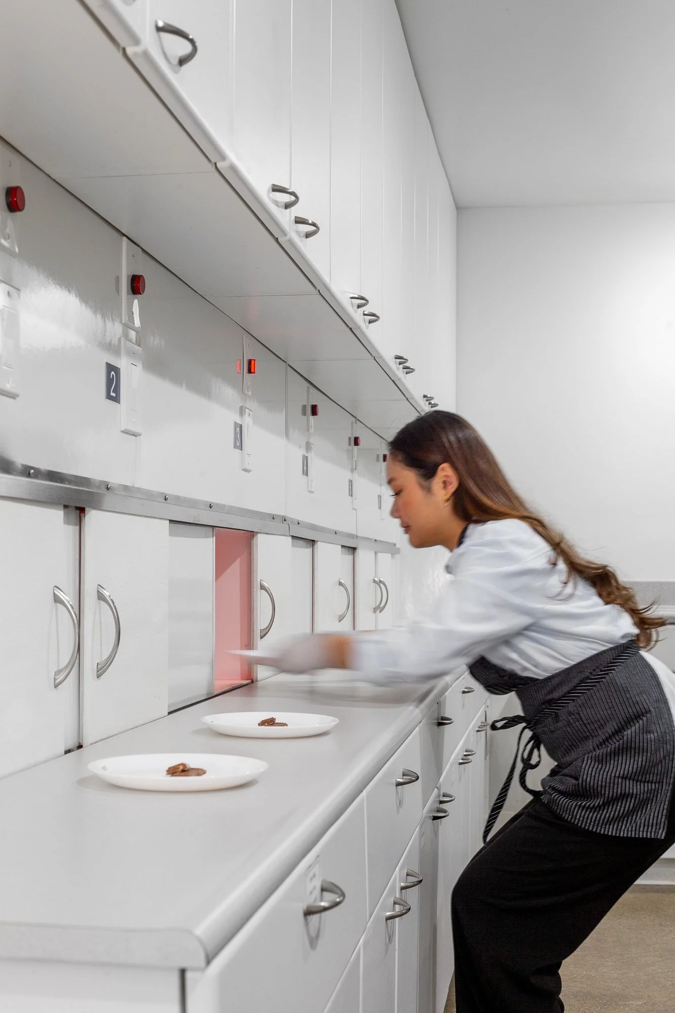 In the commercial kitchen, a research assistant passes samples through the window to the station.