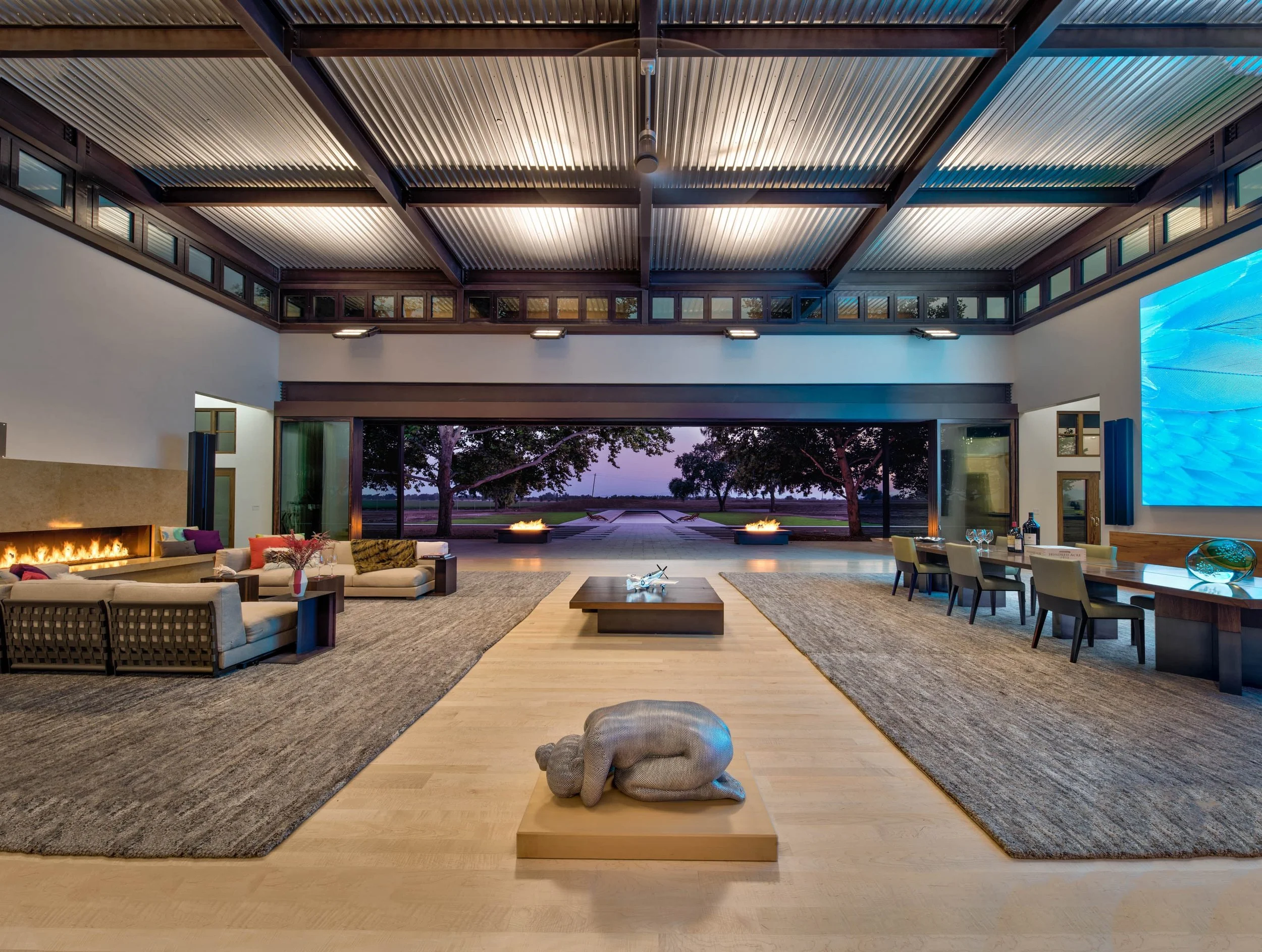 The property’s center is transparent with center-aligned glass doors at the front and back of both buildings, flowing out towards the Olympic-size swimming pool.