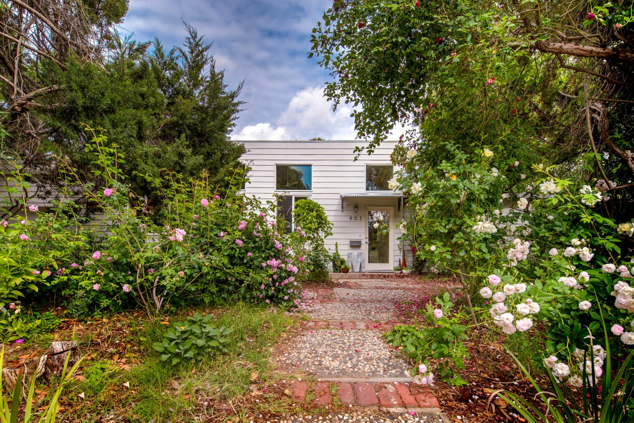 Roaming roses and lemon trees line the path to the casual, unassuming entrance.