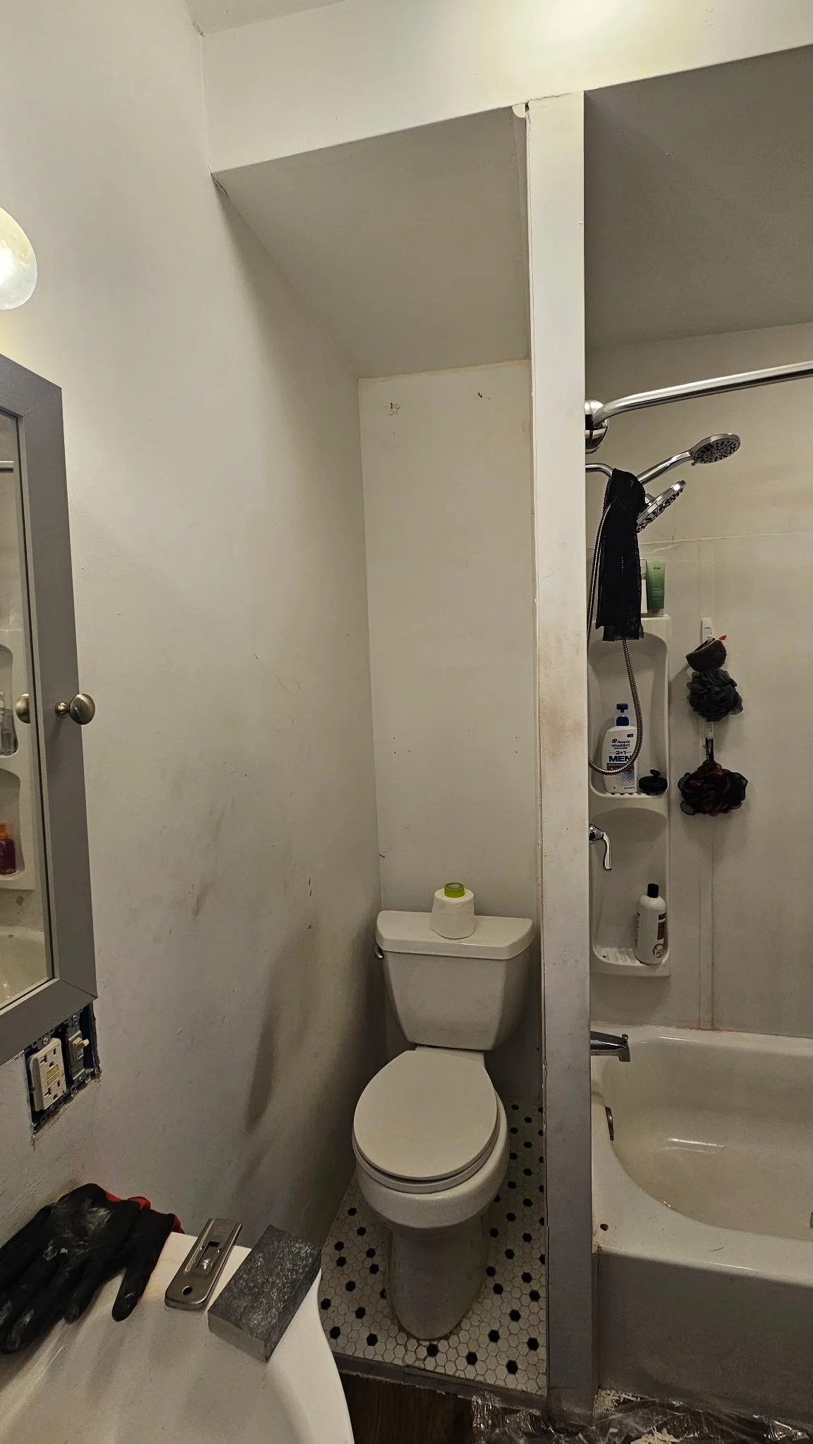Bathroom toilet with white, marked up walls prior to being painted