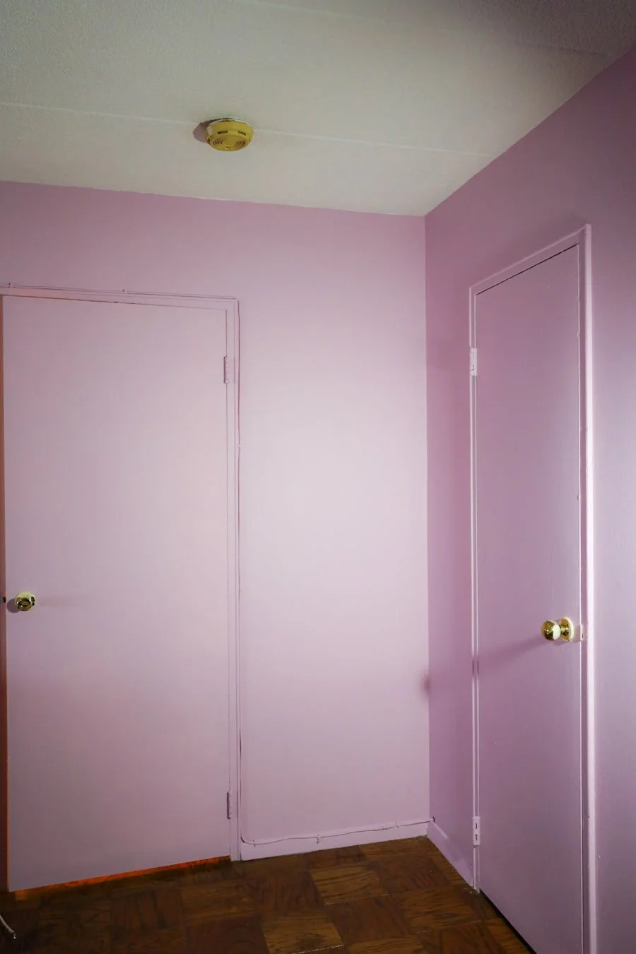 Two pink doors with golden doorknobs