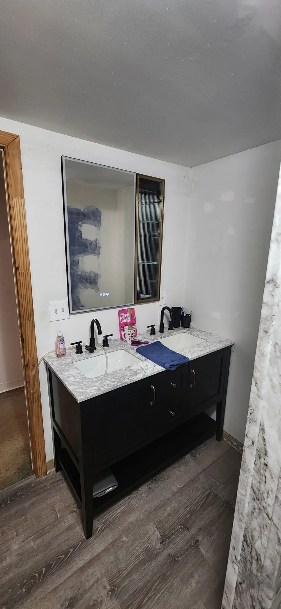 Bathroom sink with a mirror on the wall, slight patches on the drywall before painting