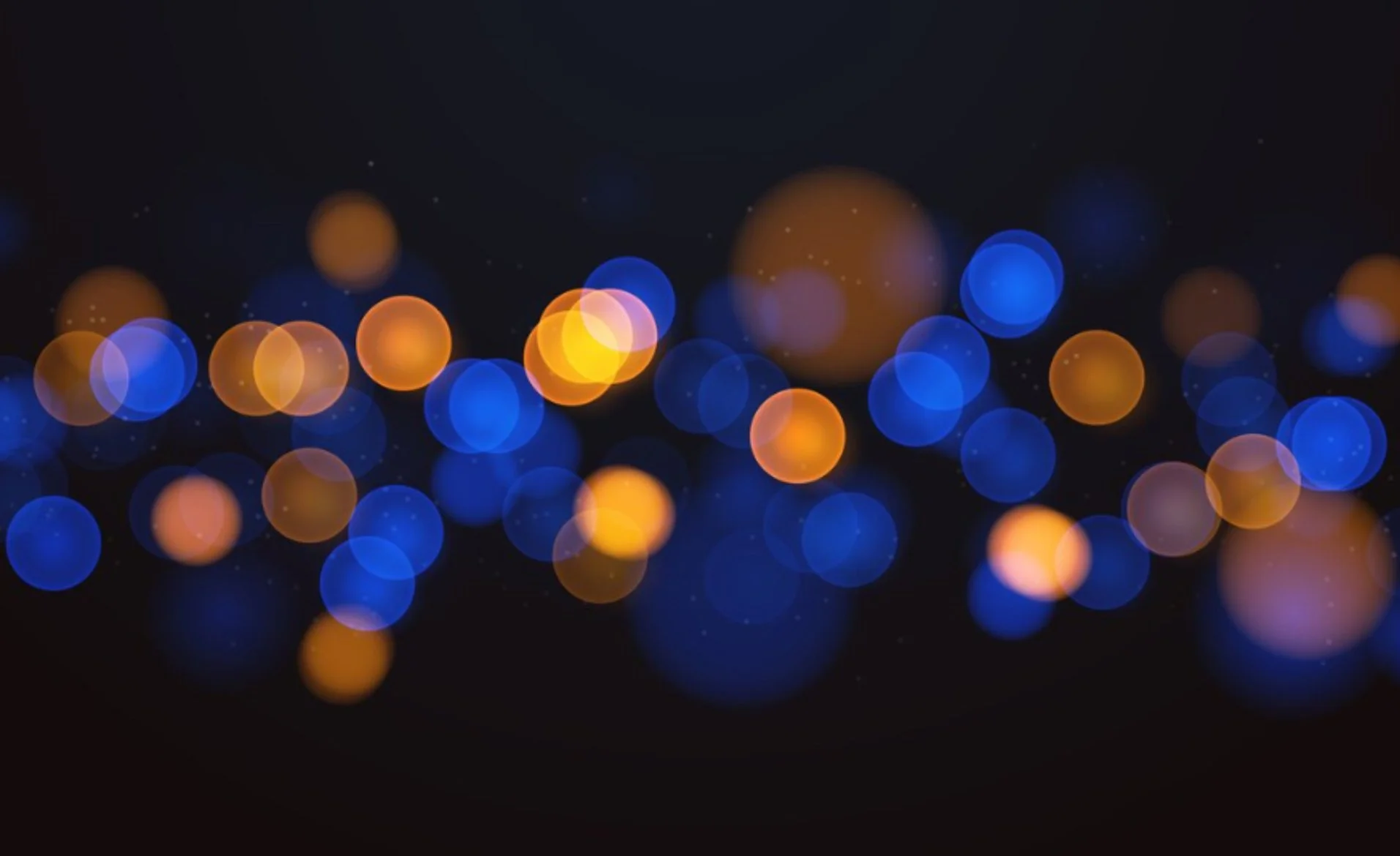 Bokeh-effect met blauwe en oranje lichtcirkels op een donkere achtergrond.