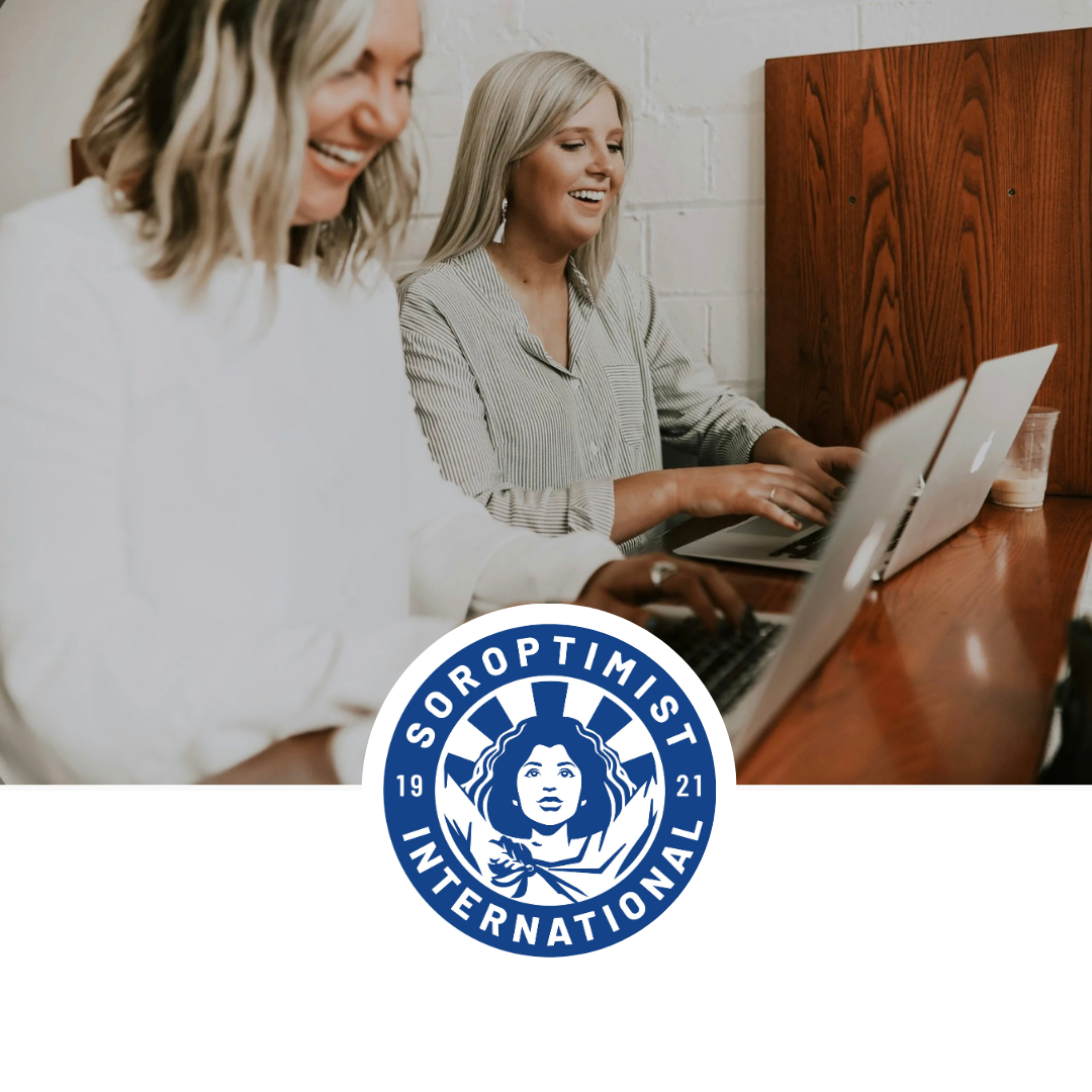 kaksi nuorta naista tietokoneiden äärellä iloisina