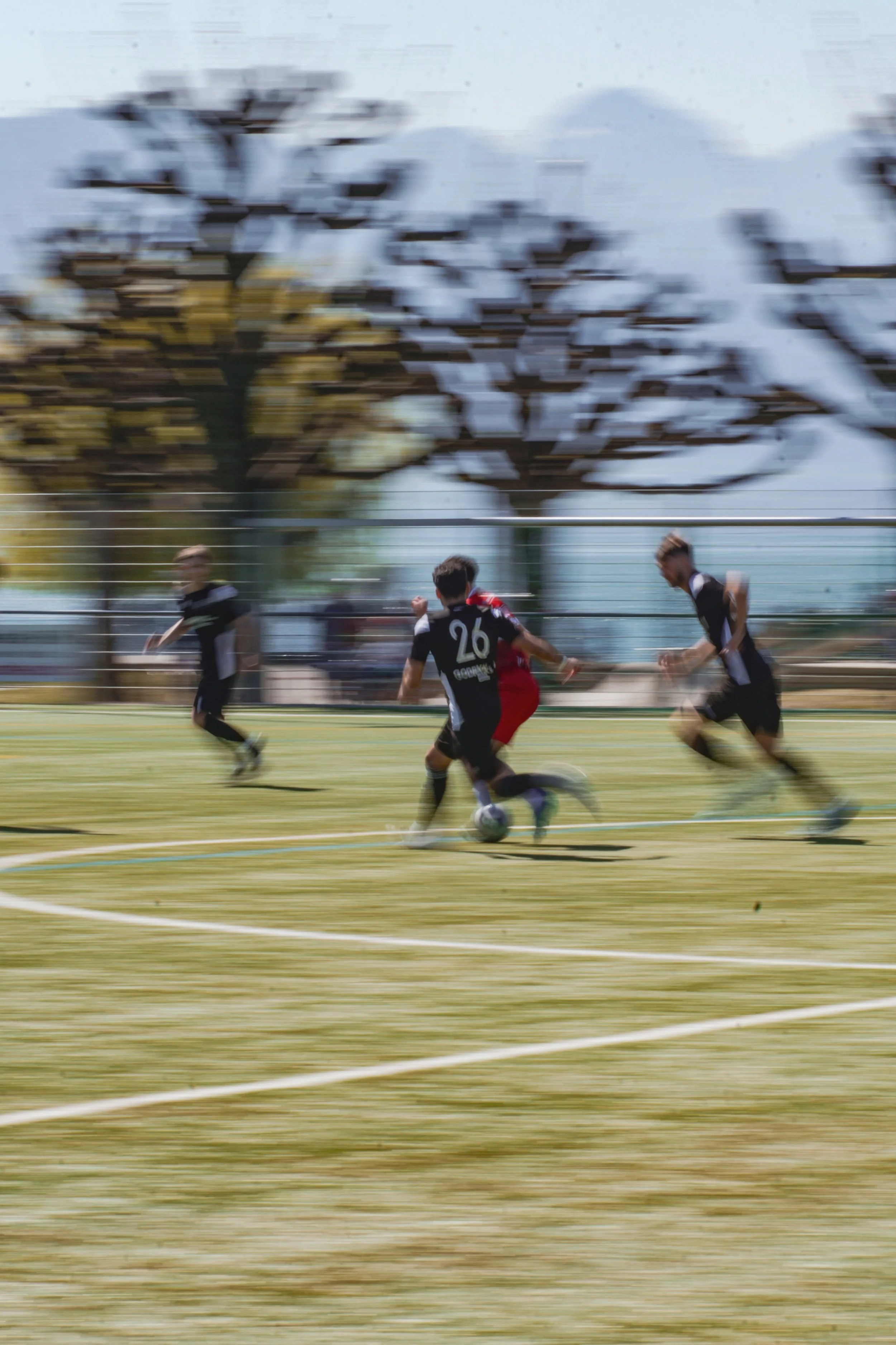 Match de football avec des joueurs en mouvement sur le terrain.