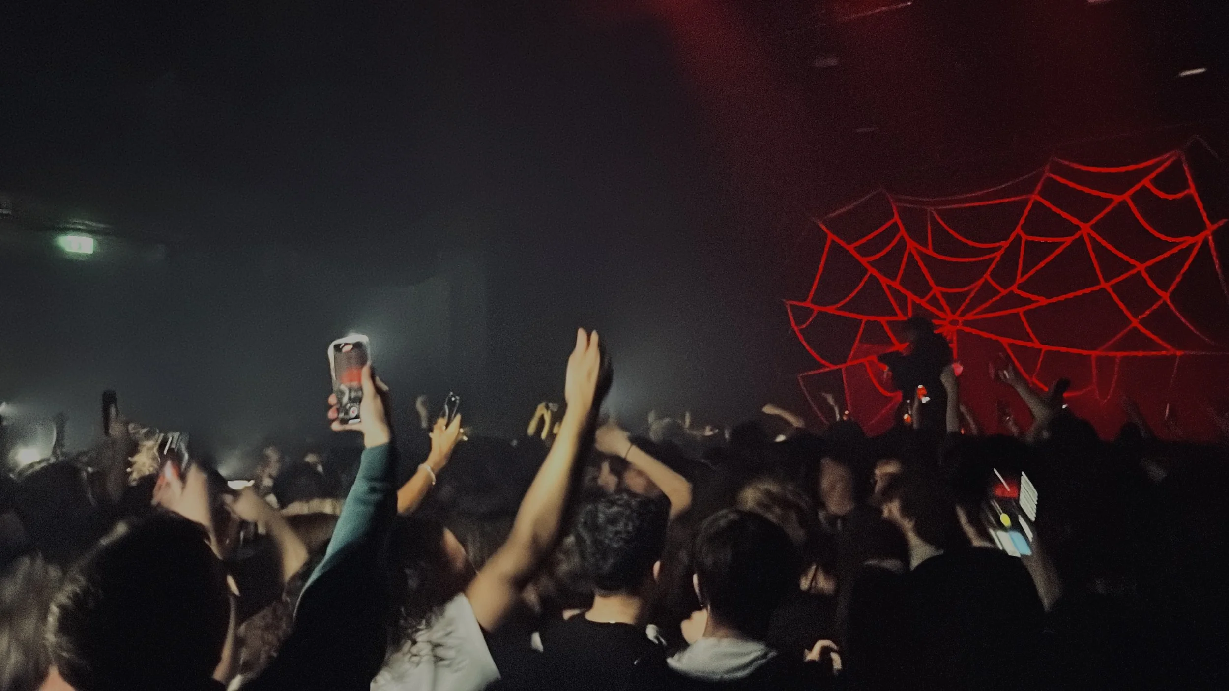 Concert avec foule et toile d'araignée rouge en arrière-plan