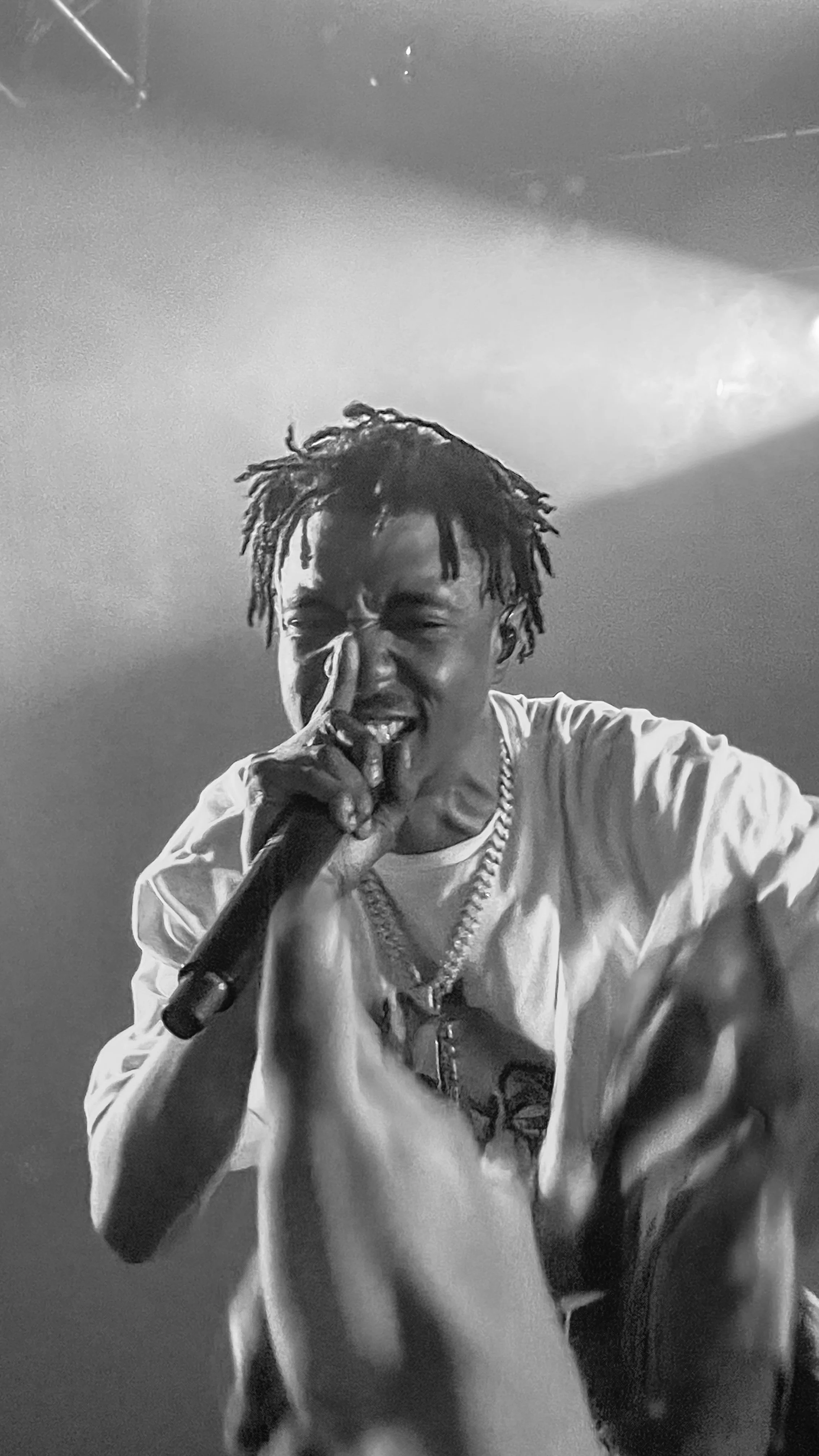 Un chanteur sur scène, tenant un micro, avec une expression intense.