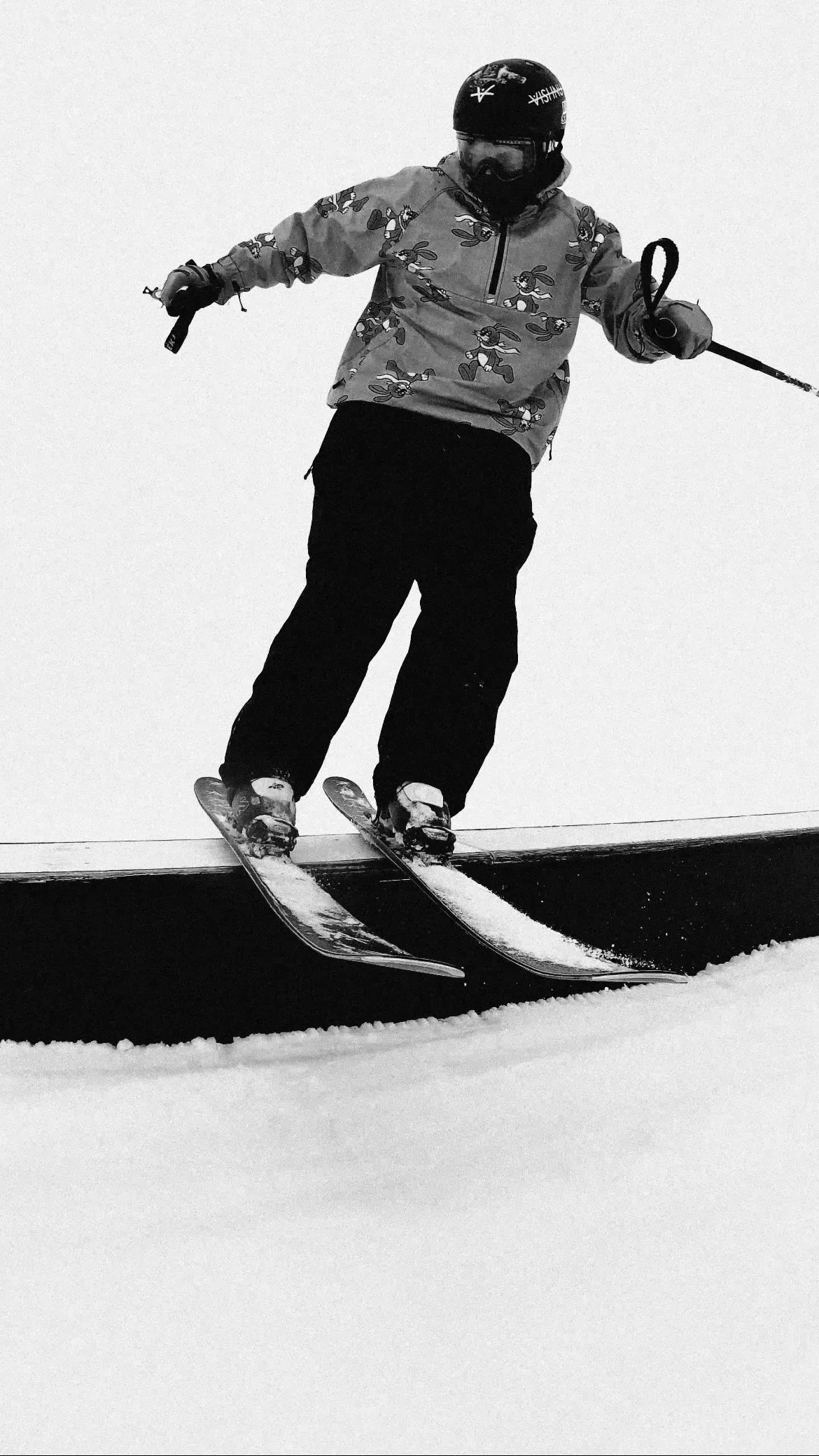 Un skieur effectue une figure sur un rail en ski freestyle.